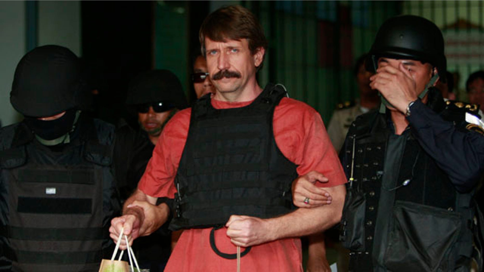 Oct. 4, 2010: With tight security and the flak jacket on, Viktor Bout, center, a suspected Russian arms dealer, leaves the criminal court in Bangkok, Thailand.