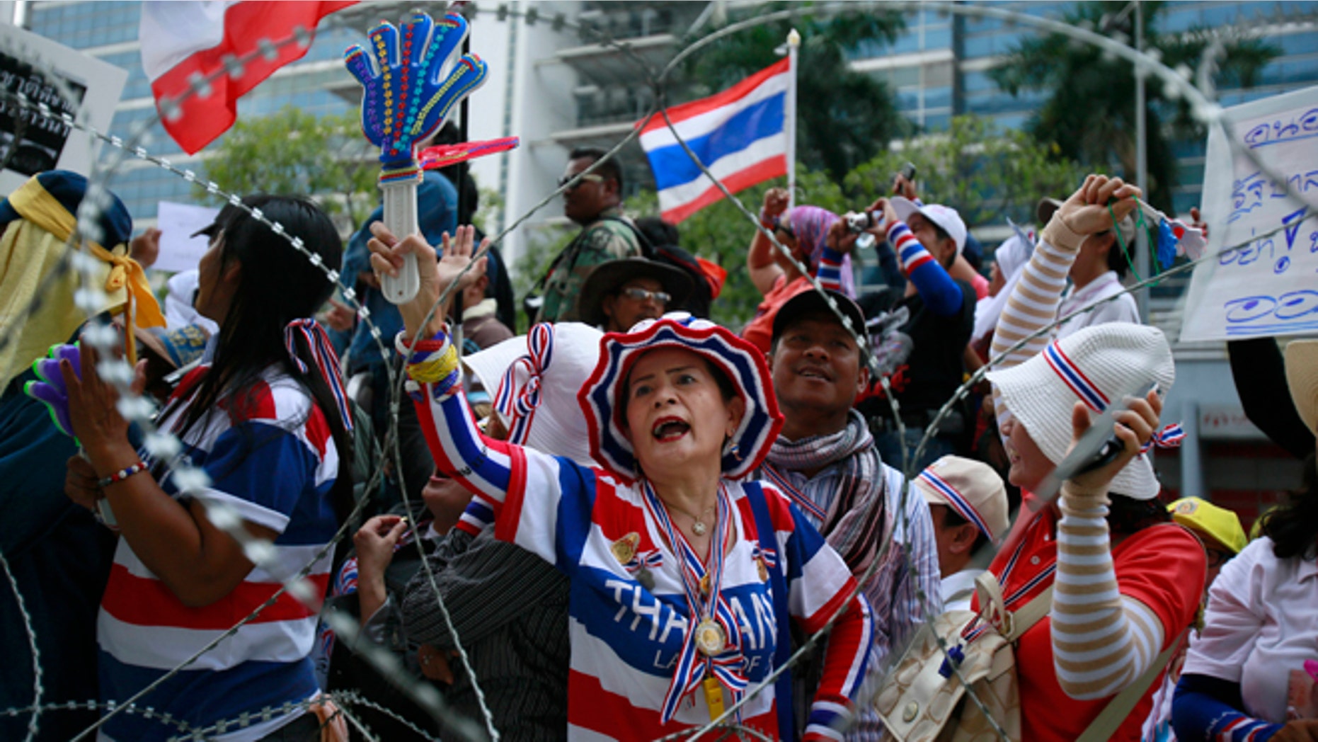 Feb. 19, 2014: Anti-government protesters shout slogans demanding Thai Prime Minister Yingluck Shinawatra to step down during a protest outside her temporary office in the building of the Permanent Secretary of Defense in northern Bangkok, Thailand.