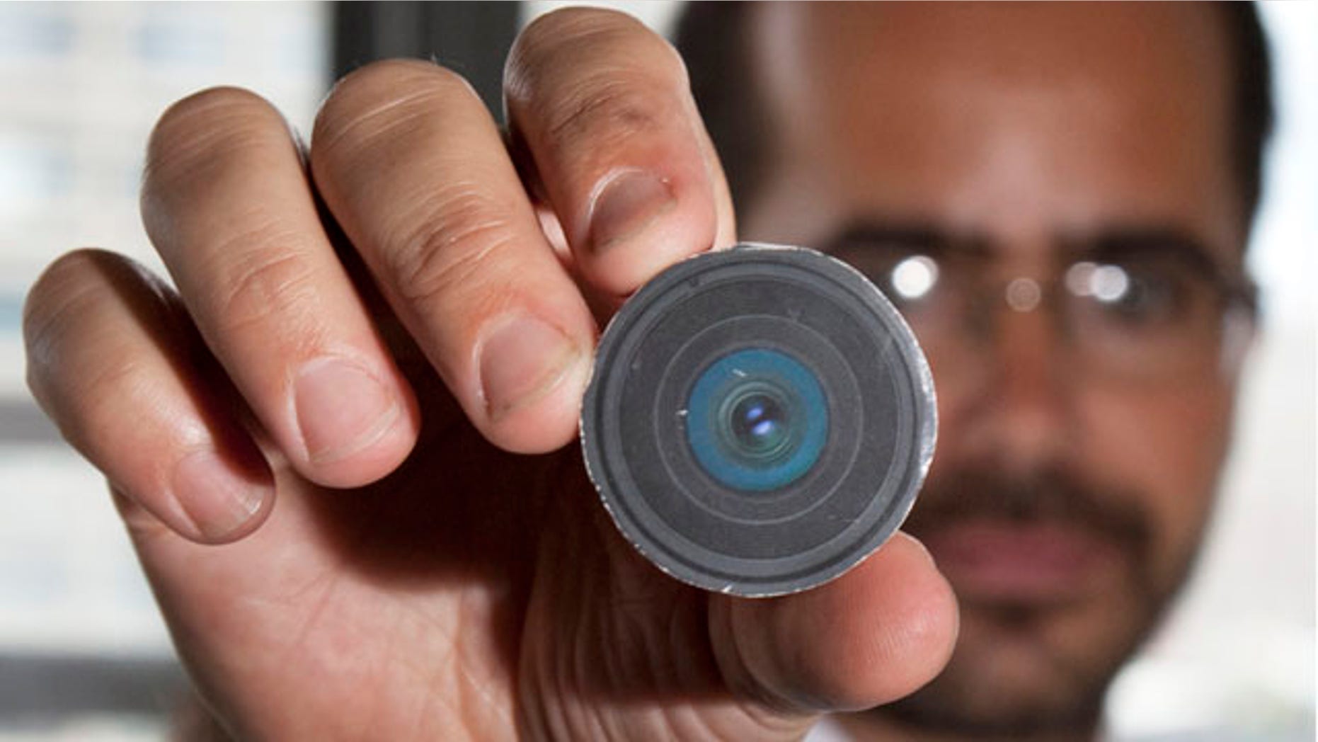 Aug. 24: New York University arts professor, Wafaa Bilal, holding the prototype of a digital camera that he had implanted in the back of his head, in New York.