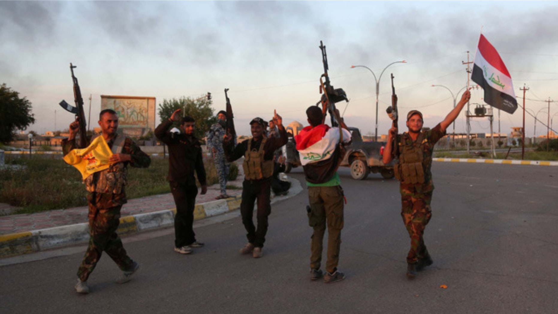 FILE - In this Tuesday, March 31, 2015 file photo, Iraqi security forces and allied Shiite militiamen celebrate in central Tikrit, 80 miles north of Baghdad. (AP Photo/Khalid Mohammed, File)