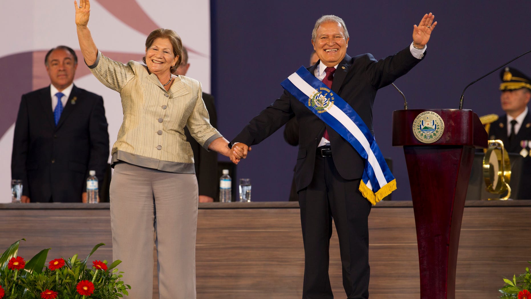 In this June 1, 2014, photo, El Salvador's incoming President, Salvador Sanchez Ceren, right, and his wife Margarita Villalta wave during his swearing in ceremony in San Salvador, El Salvador. (AP Photo/Moises Castillo)