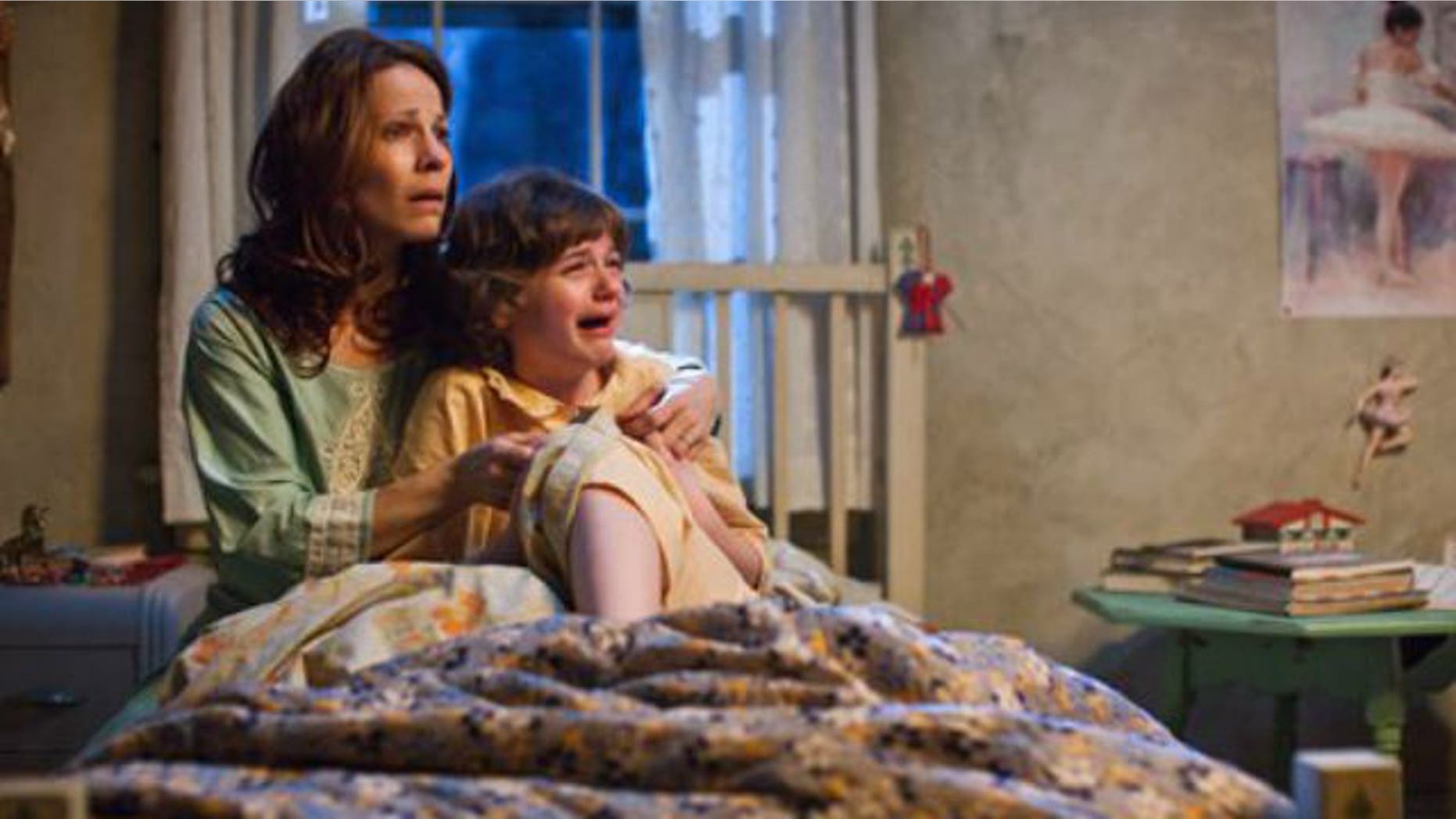 Lili Taylor portrays Carolyn Perron, left, and Joey King portrays Christine in a scene from "The Conjuring."