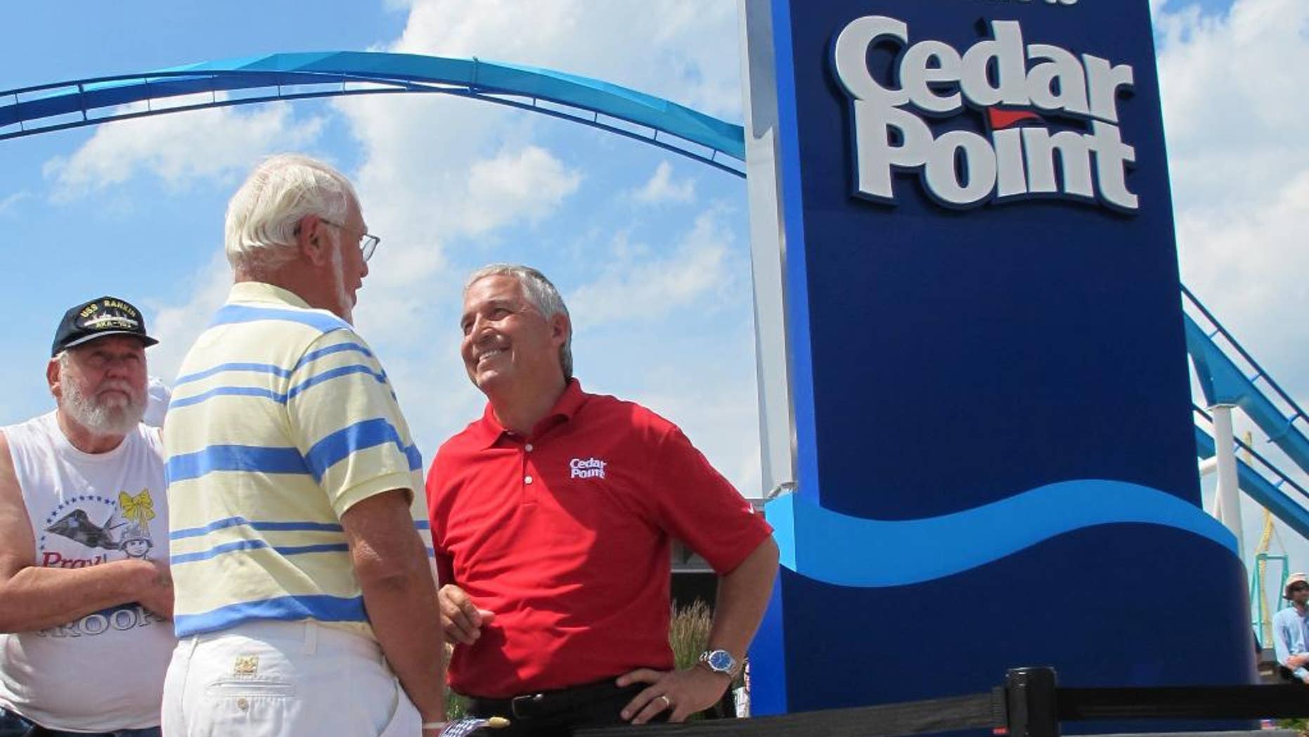 FILE - In this July 2, 2014, file photo, Matt Ouimet, chief executive of Cedar Fair Entertainment Co., greets a guest at Cedar Point amusement park, in Sandusky, Ohio. A man who entered a restricted area at the amusement park to look for a lost cellphone has been struck by a roller coaster and killed Thursday, Aug. 13, 2015. (AP Photo/John Seewer, File)