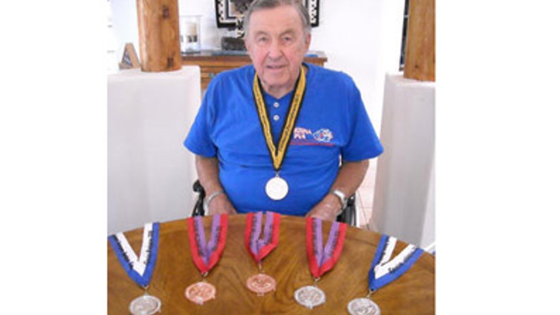 In this Sept. 16, 2011 photo, Theron Hallock sits with his medals in his Green Valley, Ariz., home. Hallock hasnt walked in 10 years but that hasnt stopped him from becoming a national-level athlete. Hallock, who turns 84 soon, recently returned from the 31st Annual National Veterans Wheelchair Games in Pittsburgh, where he took a bronze medal for the power chair relay race.