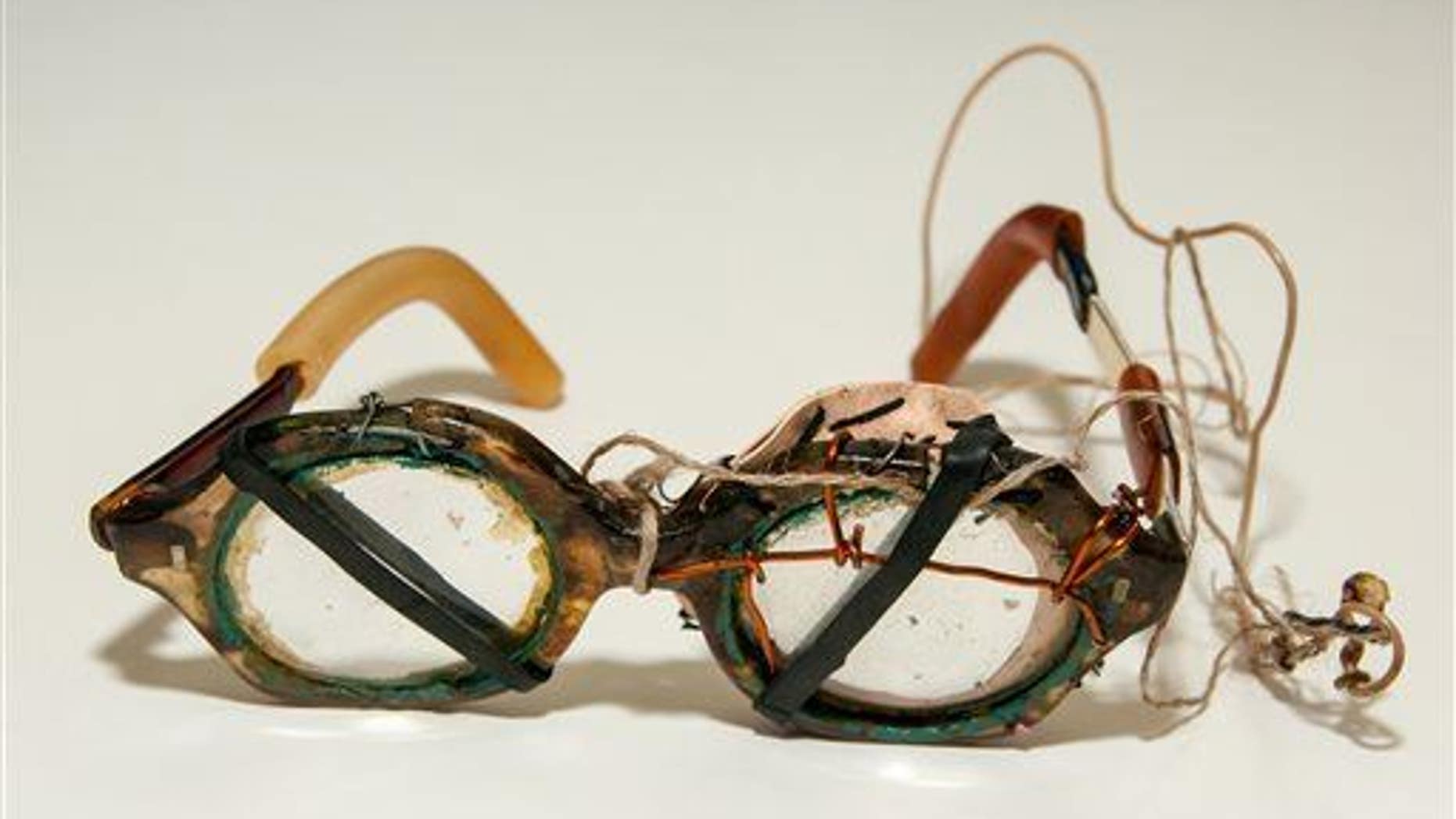 A file photo of eyeglasses held together by string, wire and rubber bands.