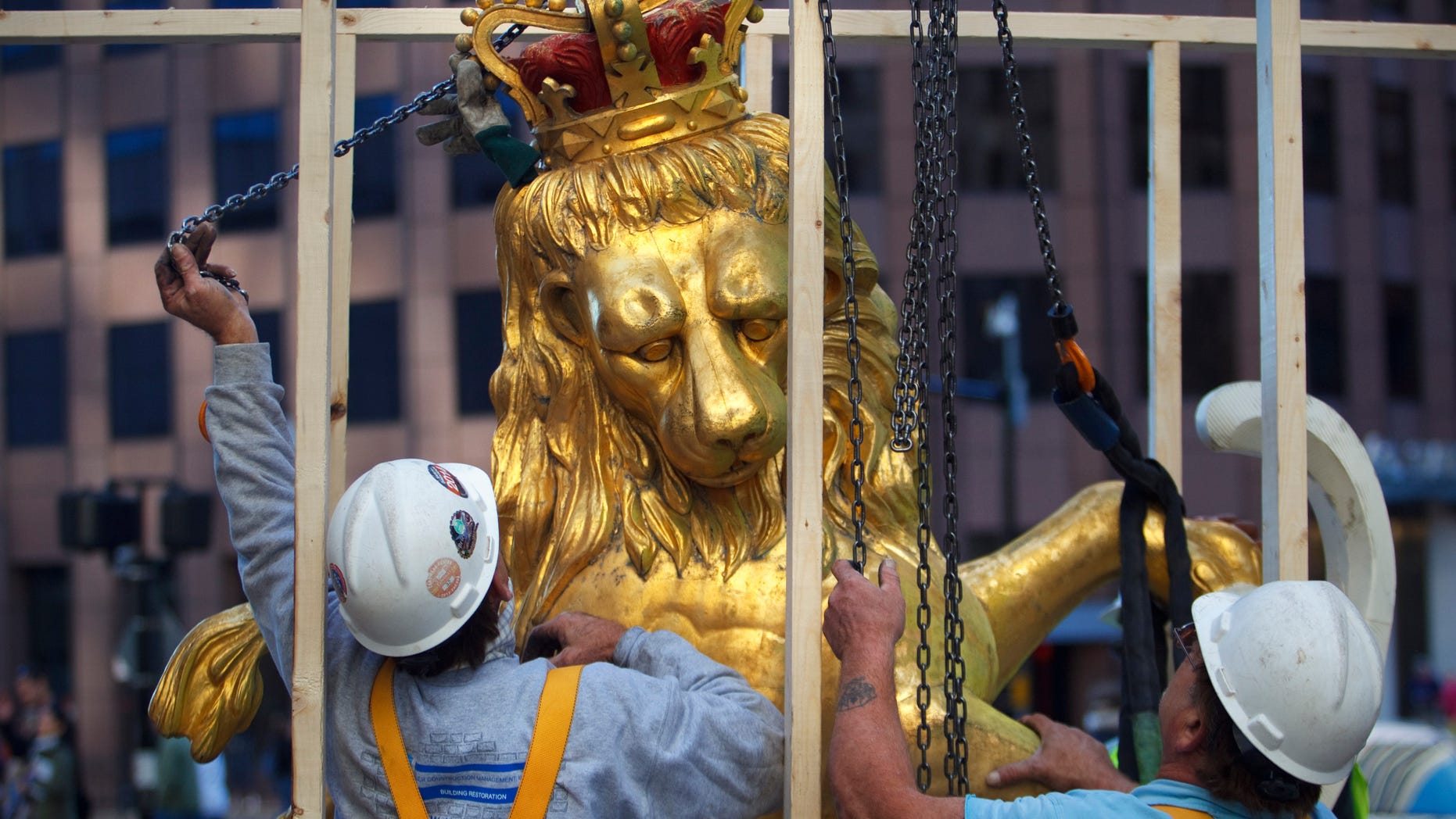 Sept. 14, 2014: A lion statue is removed from atop the Old State House on Washington Street in Boston. (AP/The Boston Globe, Dina Rudick)