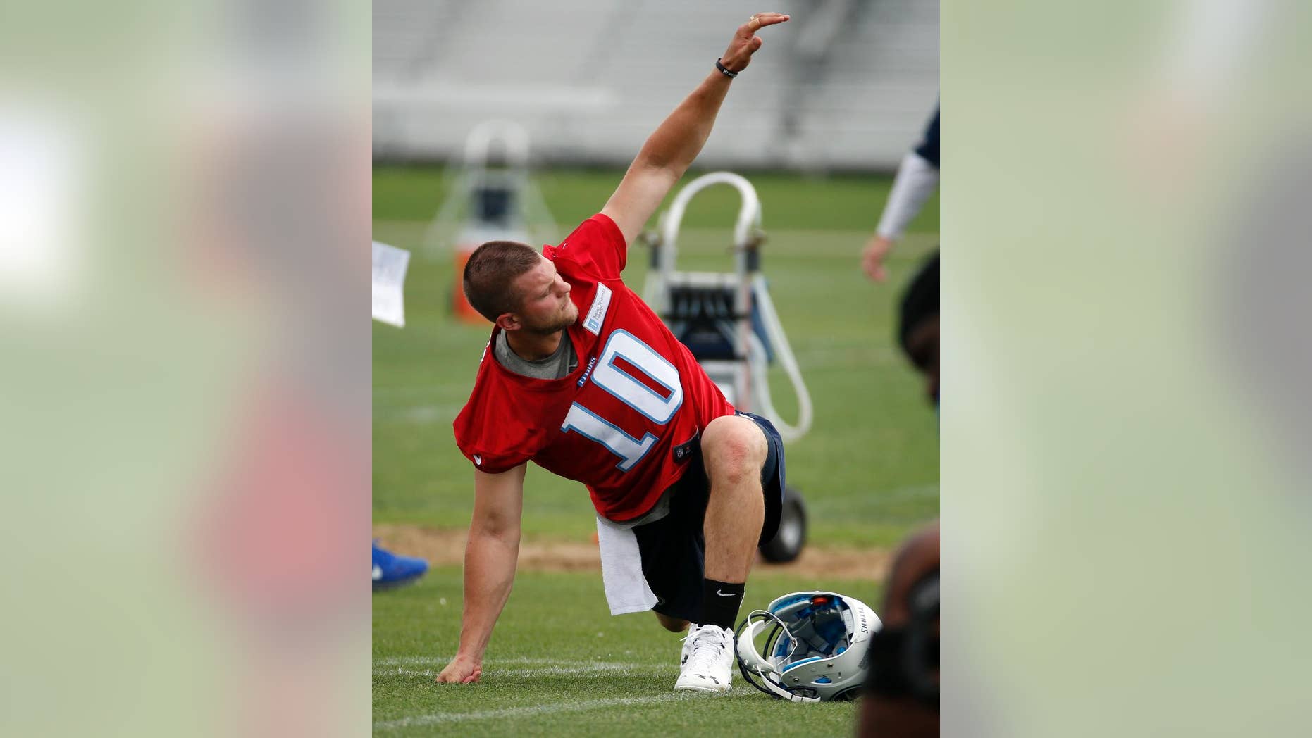 Tennessee Titans quarterback Jake Locker stretches during NFL football minicamp, Tuesday, May 27, 2014, in Nashville, Tenn. Locker is back on the field with the Titan--a couple of weeks ahead of the schedule doctors estimated for his return from an injured right foot. (AP Photo/Mark Humphrey)