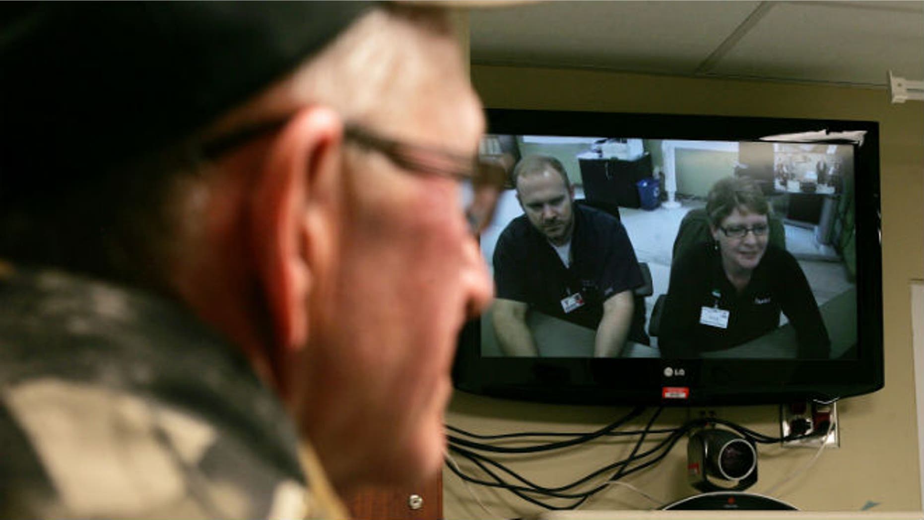 South Dakota rancher Tom Soukup looks at a video monitor at a hospital in Wagner, S.D., that connects its clinic with Avera Health physicians in Sioux Falls, SD. (AP photo/Jeremy Waltner)