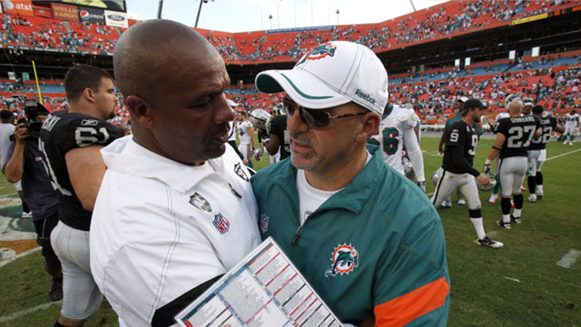 December 4, 2011: Oakland Raiders head coach Hue Jackson, left, and Miami Dolphins head coach Tony Sparano congratulate each other after the Dolphins defeated the Raiders 34-14 in an NFL football in Miami.