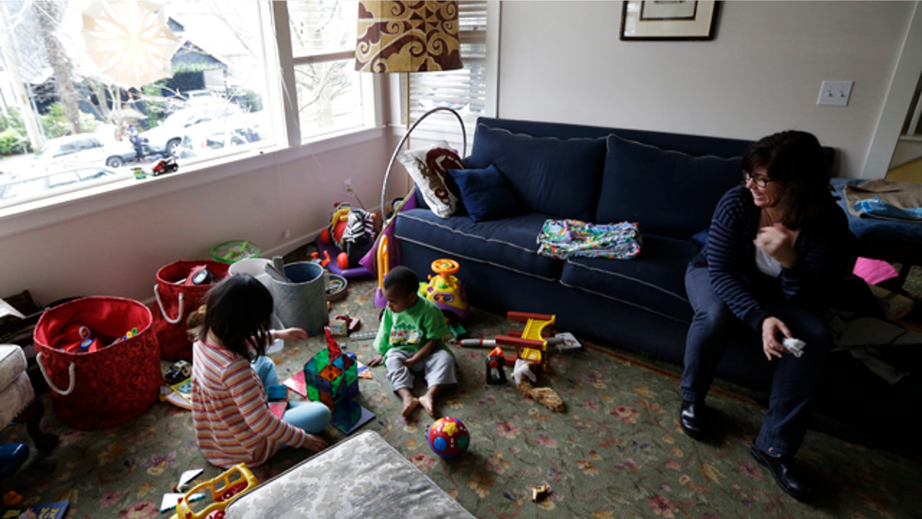Feb. 12, 2013: Nancy Jensen, right, watches as her children, Elizabeth, 6, left, and Joe, 2, center, play with a building set and other toys.