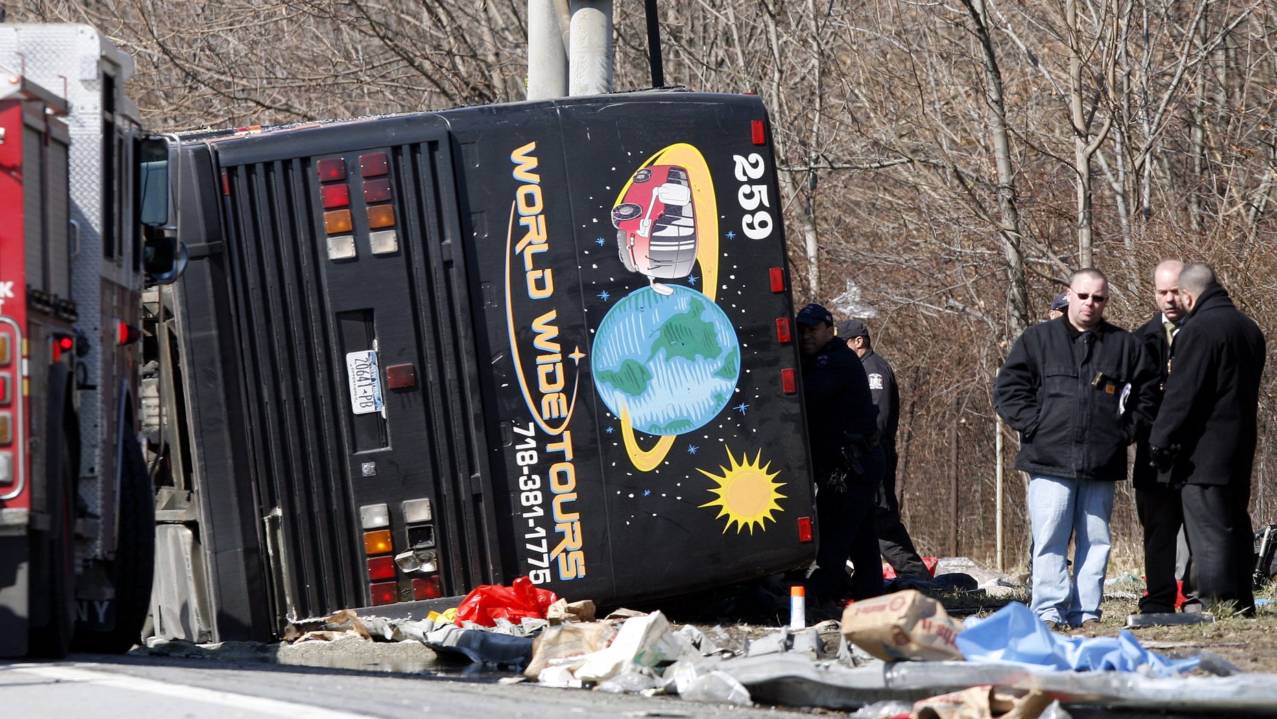 In this photo from Saturday, March 12, 2011, emergency personnel investigate the scene of a bus crash on Interstate-95 in the Bronx borough of New York.