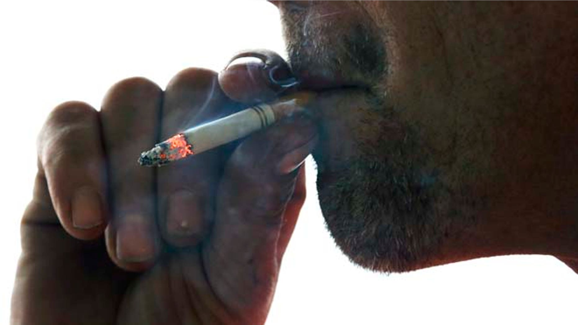 This Thursday, Nov. 6, 2014 photo shows John Cormier smoking a cigarette on Main Street in Westminster, Mass.