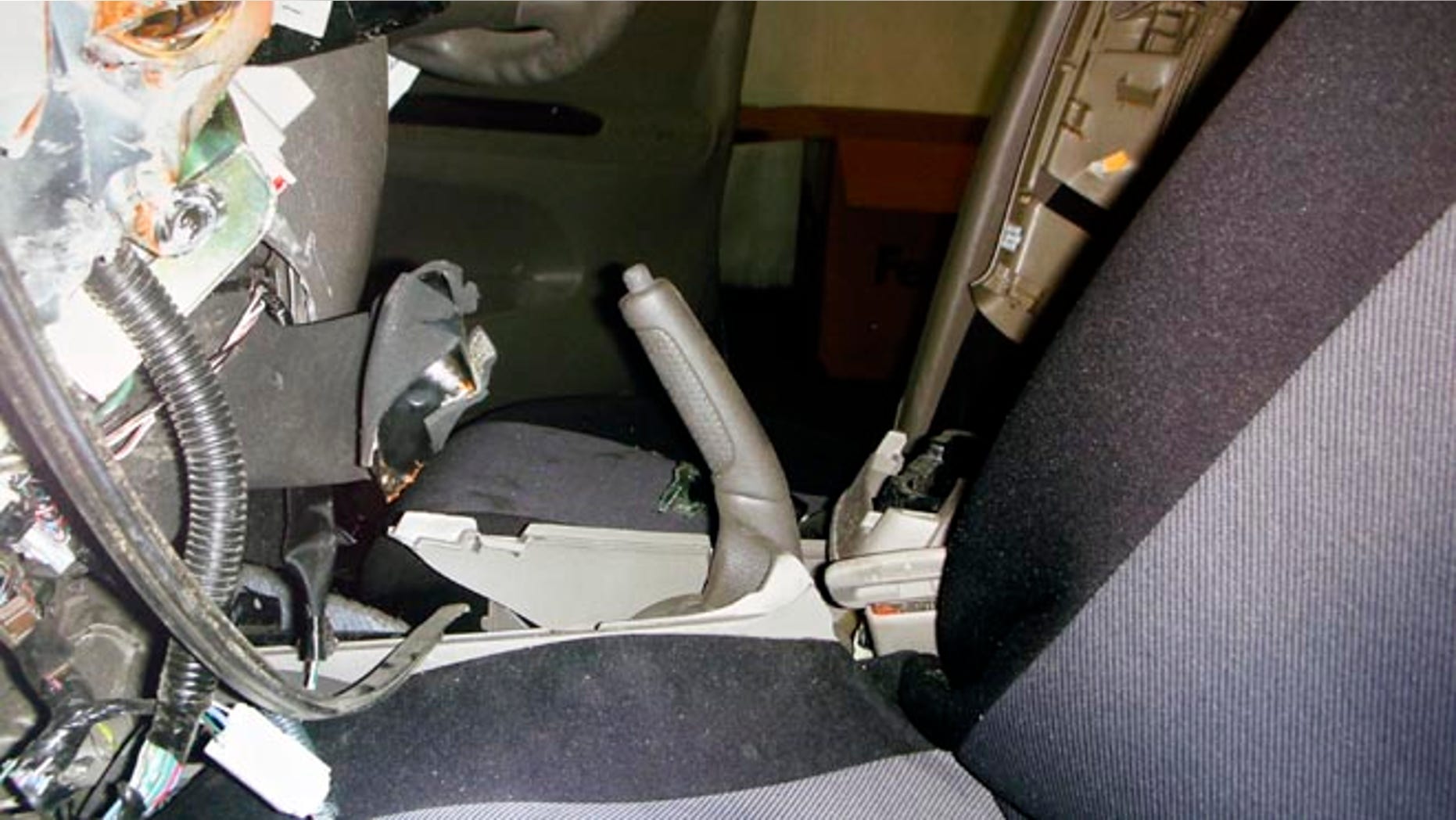 FILE - In this undated file photo displayed during a news conference by the family of the Noriko Uno, who died in an alleged "sudden unintended acceleration" auto crash in August 2009, a photo of the interior of her Toyota 2006 Camry is shown with the hand brake handle pulled all the way back. Uno's case, in which her family claims her vehicle accelerated suddenly despite her efforts, is the first headed to trial where the Japanese automaker is accused of covering up defects that led to her death. (AP Photo/Uno Family, File)