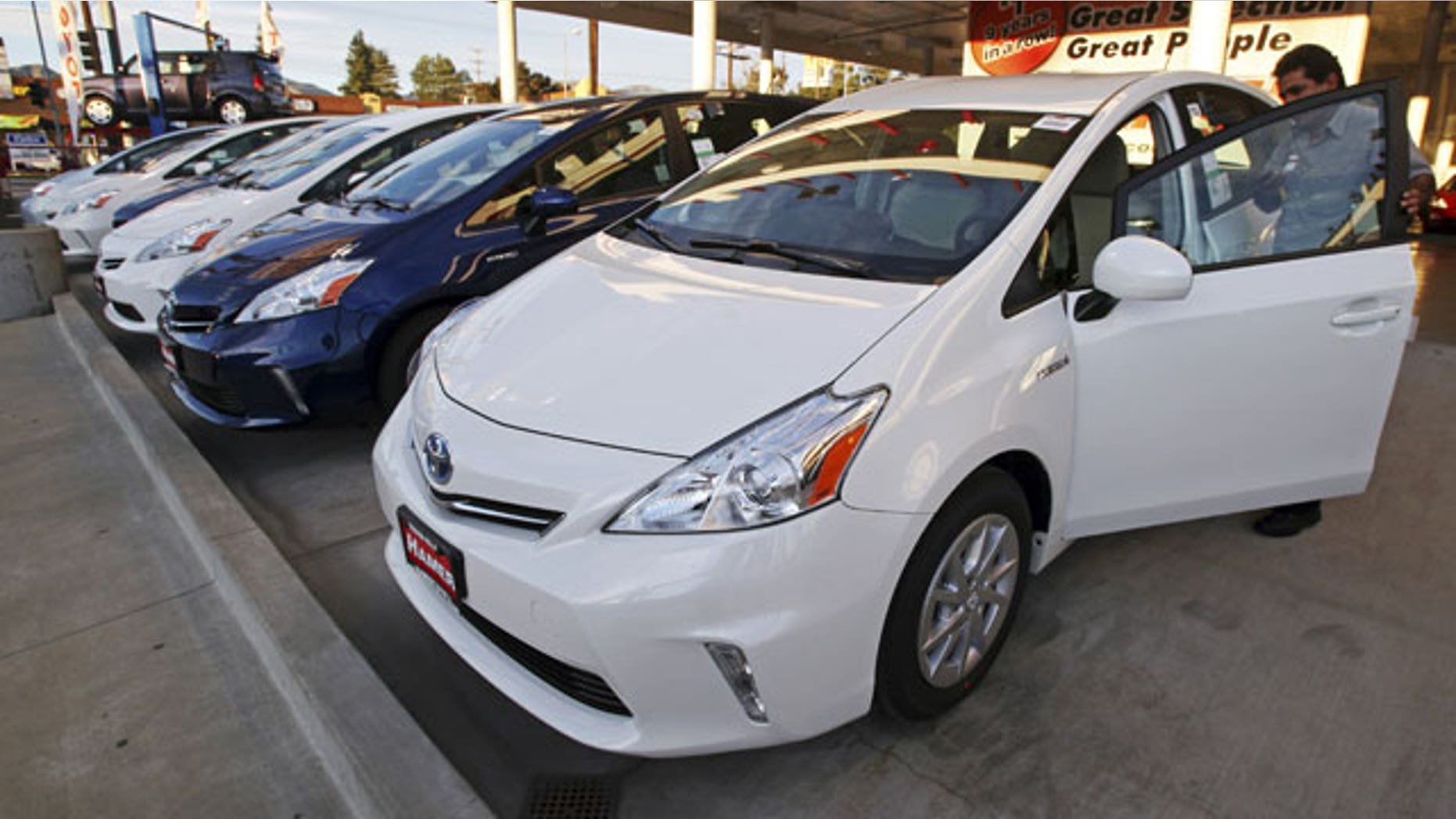 January 26, 2012: An employee parks a Toyota gas-electric hybrid automobile in a row of similar cars at a dealership in Los Angeles.