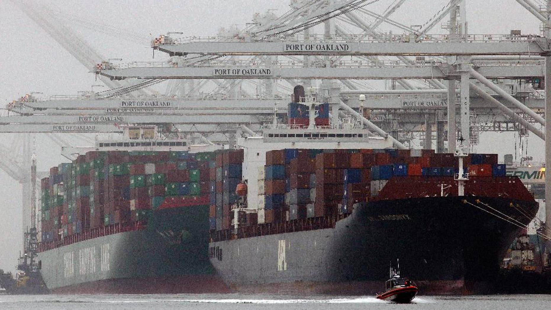 FILE - In this Wednesday, Oct. 23, 2013, file photo, container ships wait to be off loaded in a thick fog in Oakland, Calif. The Commerce Department reports on the U.S. trade deficit for February Thursday April 3, 2014 at 8:30 a.m. EDT. (AP Photo/Ben Margot, File)
