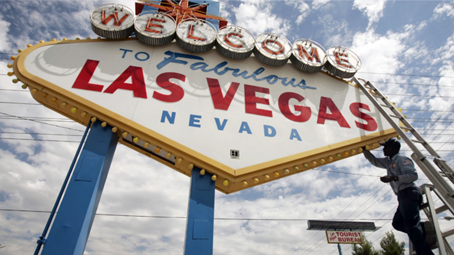 FILE - This July 28, 2005 file photo shows an electric company worker changing ballasts and lamps on the "Welcome to Las Vegas," sign in Las Vegas, Nev. Deals for round-trip airfare to Vegas along with inexpensive hotel packages are among the last-minute offers that travelers with flexible vacation schedules can find online, but the ability to book fast before the deals disappear is often key. (AP Photo/Joe Cavaretta, file)