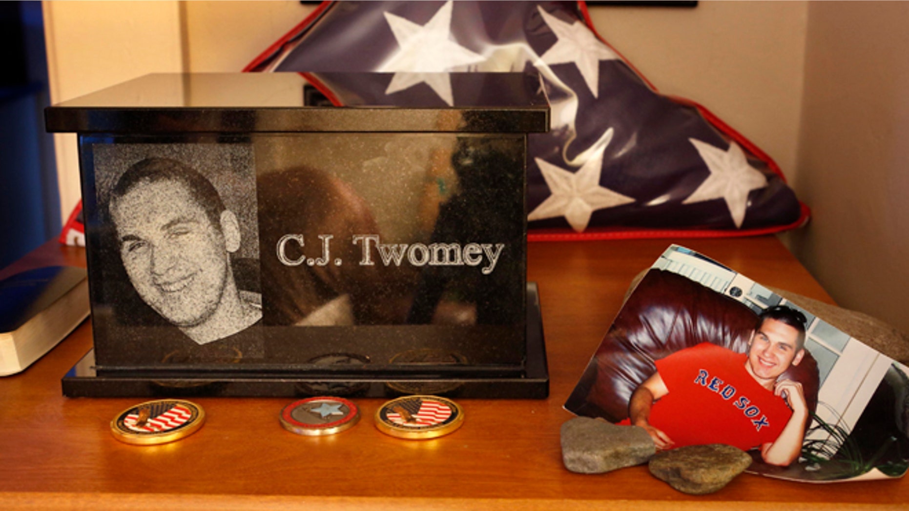This Dec. 17, 2013, photo shows an urn containing the ashes of C.J. Twomey on a shelf at his parent's home in Auburn, Maine. C.J.'s mother, Hallie Twomey, is asking people to help scatter his ashes throughout the world so he can become part of the world he never got to see.
