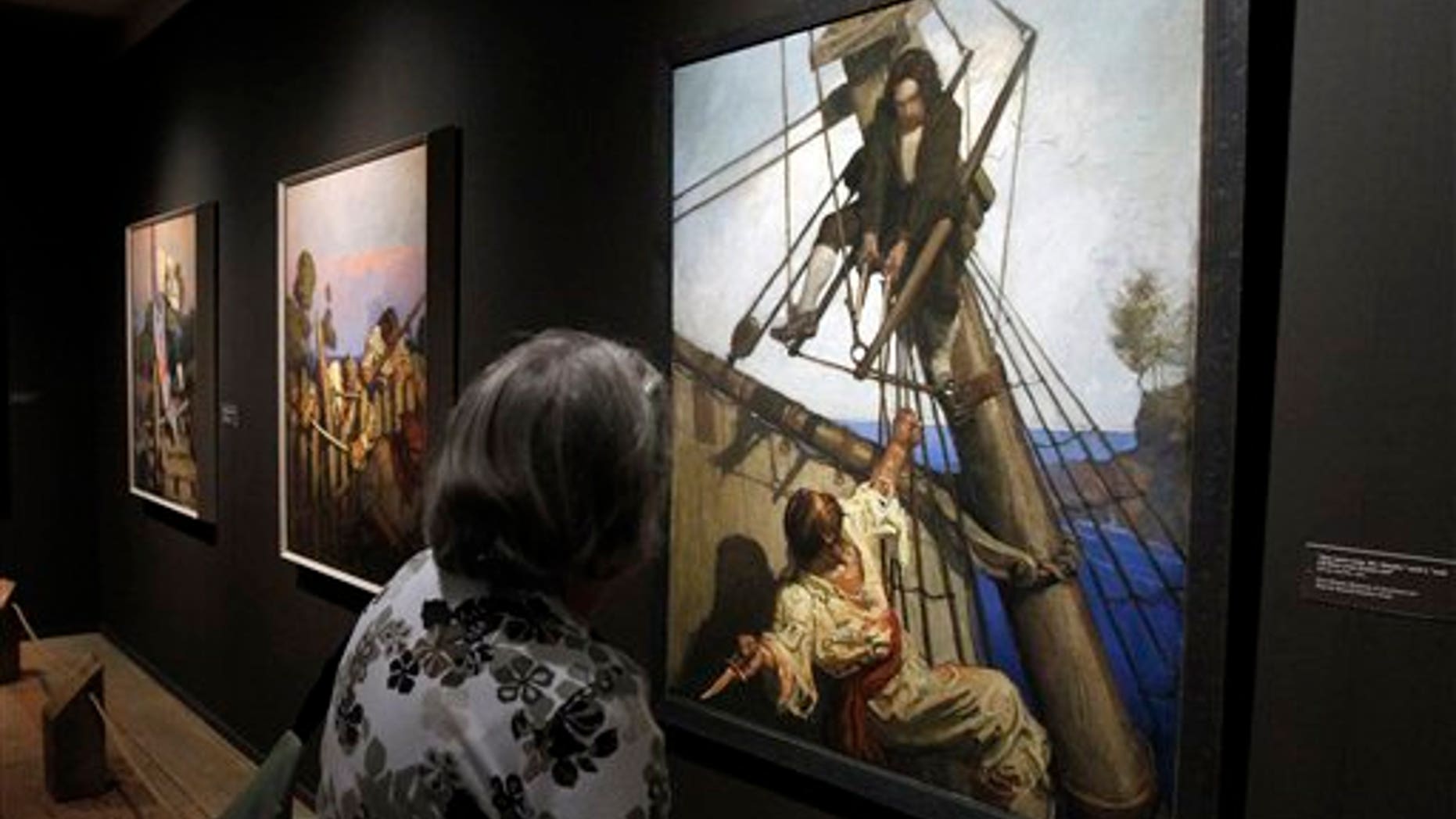 In this Sept. 13, 2011 photo, a gallery goer looks at an exhibit of N.C. Wyeths Treasure Island, Classic Illustrations for a Classic Tale at the Brandywine River Museum in Chadds Ford, Pa. This year is the 100th anniversary of the publication of Robert Louis Stevensons Treasure Island with illustrations by N.C. Wyeth, and all 16 paintings created by Wyeth will be on display together for the first time since they left the artists studio a century ago. (AP Photo/Alex Brandon)