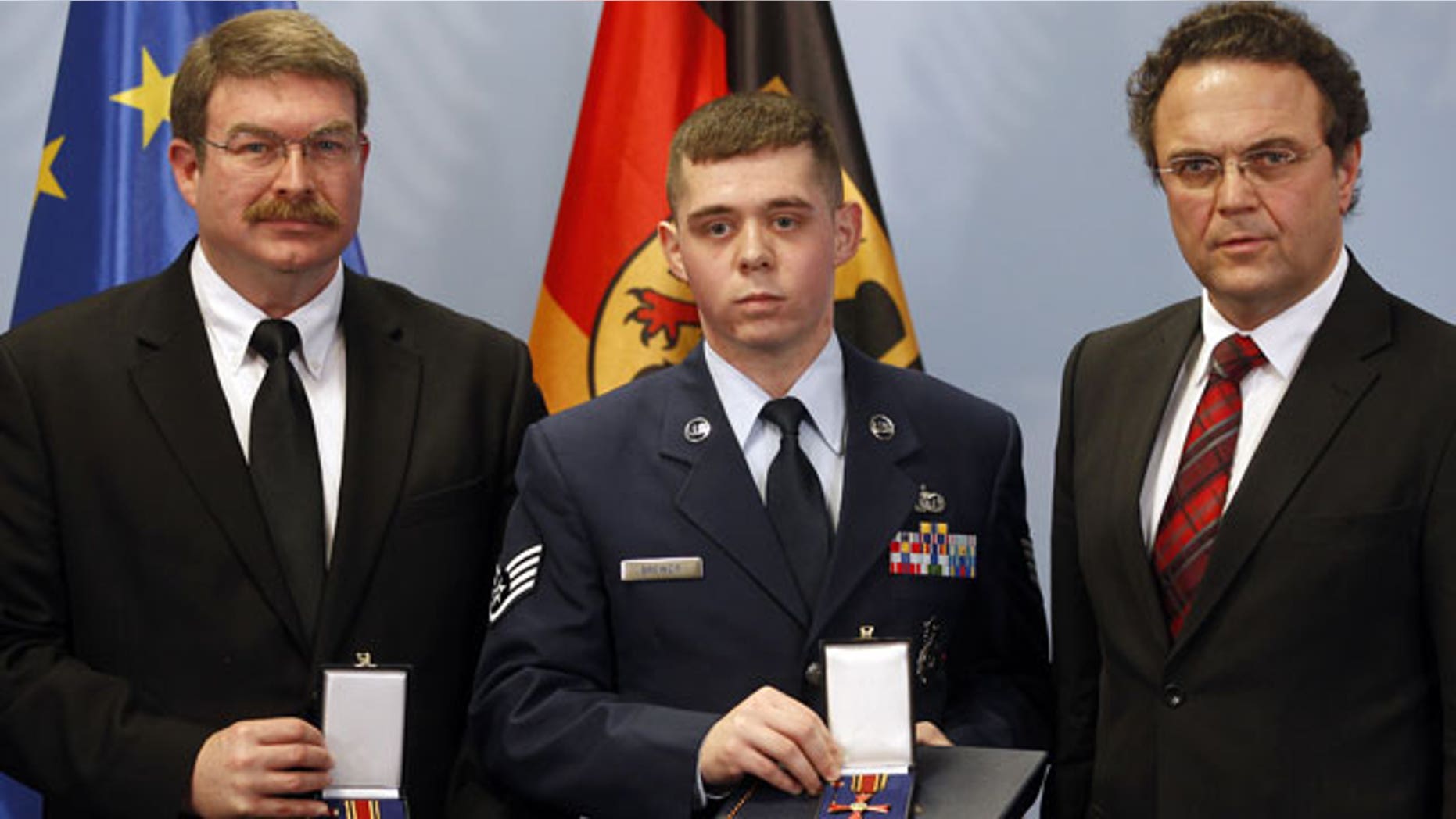 January 16, 2012: Frankfurt airport employee Lamar Joseph Connor, left, from Altha, Florida, and US Staff Sergeant Trevor Donald Brewer, center, from Gray, Tennessee are awarded with The Cross of Merit of the Federal Republic of Germany by German Interior Minister Hans-Peter Friedrich , right, in Berlin, Germany.