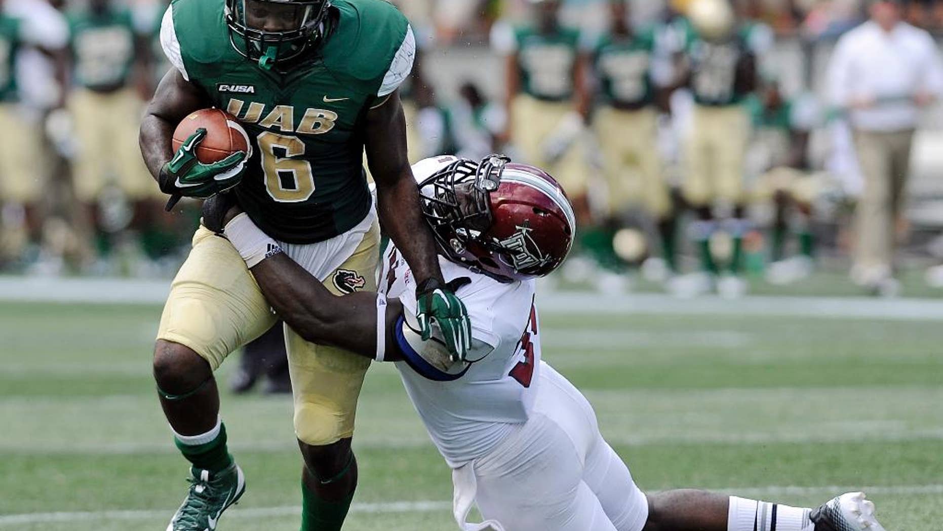 UAB running back D.J. Vinson (6) attempts to break away from Troy linebacker Mark Wilson (35) during the first half an NCAA college football in Birmingham, Ala., Saturday, Aug. 30, 2014. (AP Photo/The (Troy) Messenger, Thomas Graning)