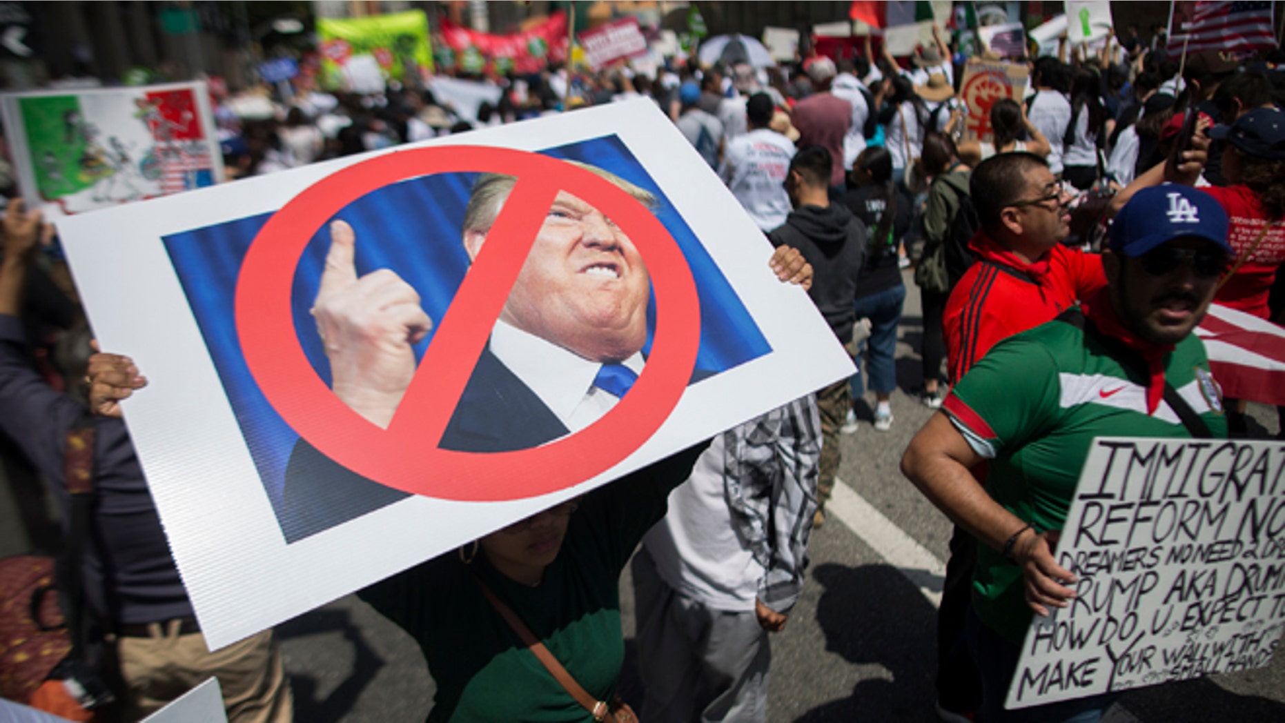 A woman carries a placard critical of Republican presidential candidate Donald Trump during one of several May Day marches on May 1, 2016 in Los Angeles, California. (Photo by David McNew/Getty Images)