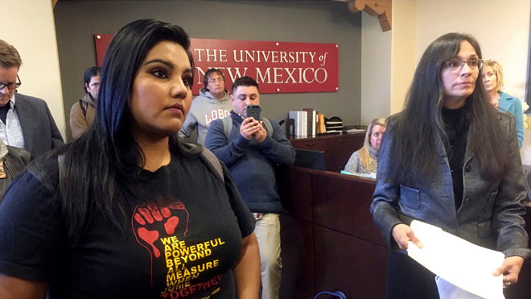 University of New Mexico student LuzHilda Campos, left, and Chicano studies professor Irene Vasquez, right, present a letter with hundreds of signatures on Friday, Nov. 18, 2016, to school president Bob Frank asking him to declare the campus a "sanctuary university," in Albuquerque, N.M. A group of professors at the largest university in the nation's most Hispanic state are asking for more protection of immigrant students following the election of Republican Donald Trump. (AP Photo/Russell Contreras)