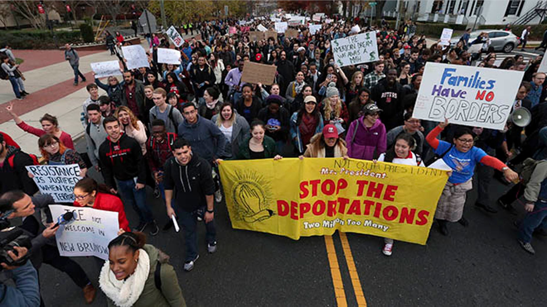 Hundreds of Rutgers University students block College Ave., in New Brunswick, N.J., as they march to protest some of President elect Donald Trump's policies and to ask school officials to denounce some of his plans at Rutgers University Wednesday, Nov. 16, 2016, in New Brunswick, N.J. College students at campuses around the United States say they are planning rallies and walkouts to call on school administrators to protect students and employees against immigration proceedings under Donald Trump's presidency. (AP Photo/Mel Evans)