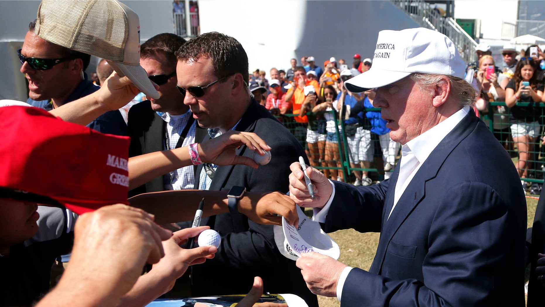 GOP presidential candidate Donald Trump signs autographs during the final round of the Cadillac Championship golf tournament, Sunday, March 6, 2016, in Doral, Fla. (AP Photo/Wilfredo Lee)