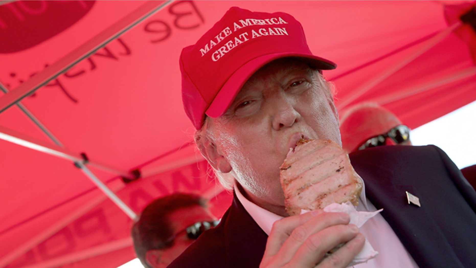 DES MOINES, IA - AUGUST 15: Republican presidential candidate Donald Trump eats a pork chop on a stick and gives a thumbs up sign to fairgoers at the Iowa State Fair on August 15, 2015 in Des Moines, Iowa. Presidential candidates are addressing attendees at the Iowa State Fair on the Des Moines Register Presidential Soapbox stage and touring the fairgrounds. The State Fair runs through August 23. (Photo by Win McNamee/Getty Images)