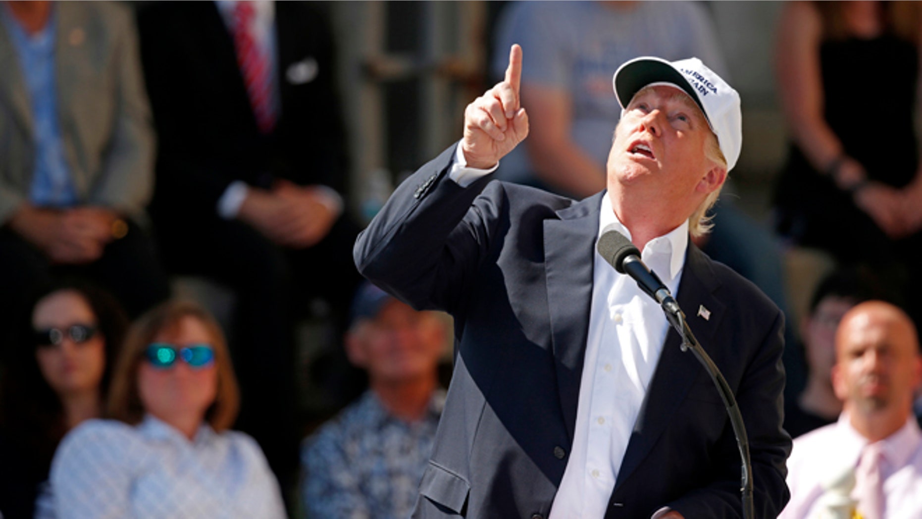 Donald Trump points to an airplane passing overhead Thursday, June 30, 2016, in Manchester, N.H.