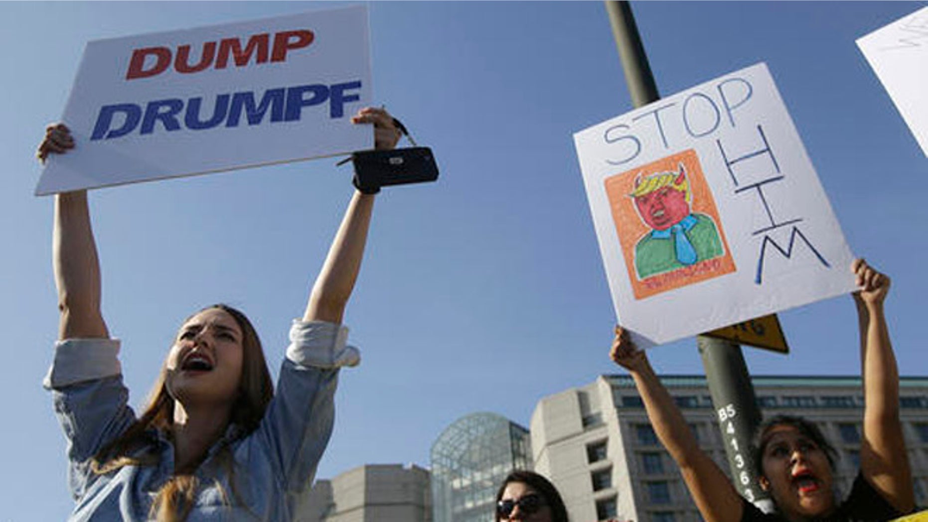 Women hold up signs protesting Donald Trump outside of the Hyatt Regency hotel before the California Republican Party 2016 Convention in Burlingame, Calif., Friday, April 29, 2016. (AP Photo/Jeff Chiu)