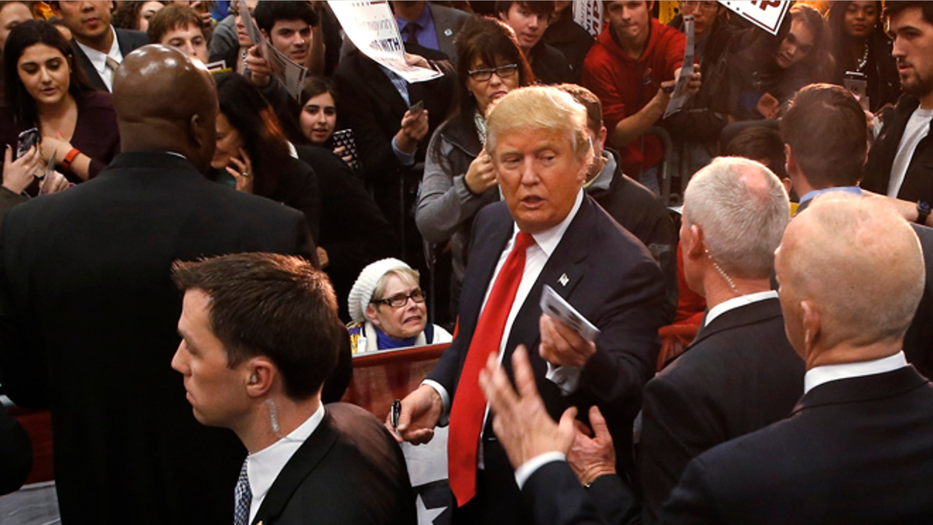Republican presidential candidate Donald Trump hands a memento to staff during a campaign event at the University of Iowa Field House, Tuesday, Jan. 26, 2016 in Iowa City, Iowa. (AP Photo/Paul Sancya)