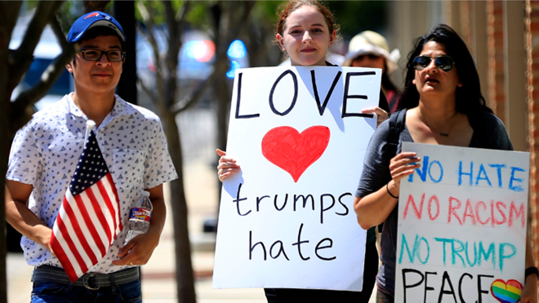 DALLAS, TX - JUNE 16: Protestors walk before Republican presidential candidate Donald Trump's rally on June 16, 2016 at Gilley's in Dallas, Texas. Trump arrived in Texas on Thursday with plans to hold rallies and fundraisers. (Photo by Ron Jenkins/Getty Images)
