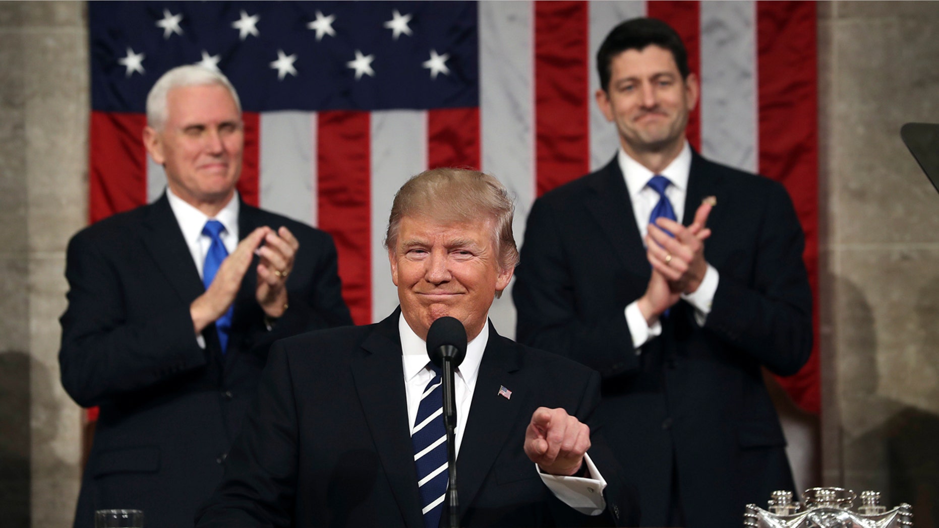 President Donald Trump, flanked by Vice President Mike Pence and House Speaker Paul Ryan of Wis., gestures on Capitol Hill in Washington, Tuesday, Feb. 28, 2017, before his address to a joint session of Congress. (Jim Lo Scalzo/Pool Image via AP)
