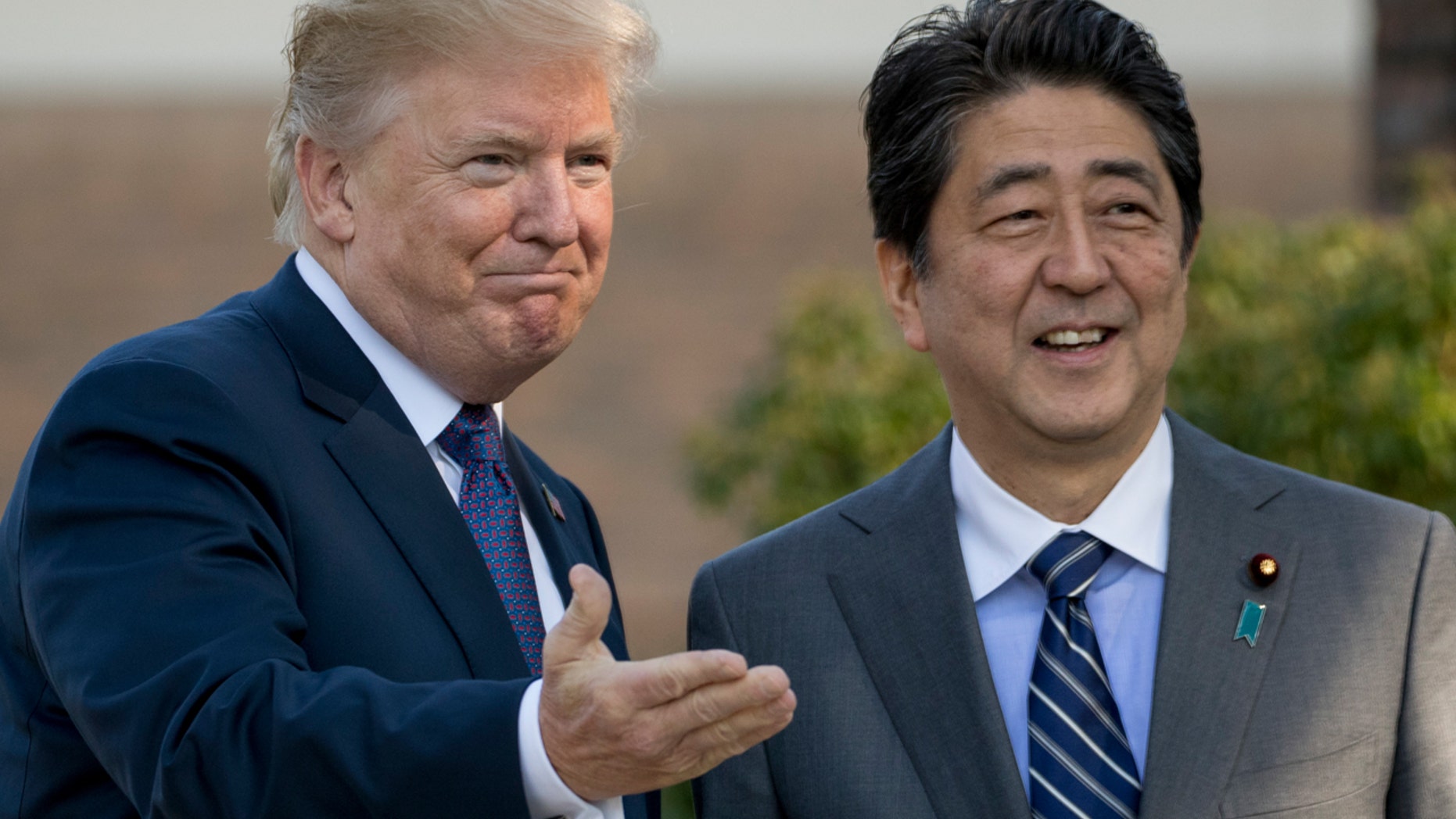 U.S. President Donald Trump and Japan's Prime Minister Shinzo Abe greet one another at Kasumigaseki Country Club outside Tokyo, Nov. 5, 2017.