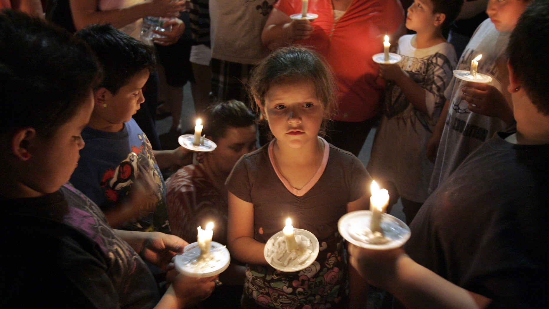 April 22: Children with their parents light and hold candles at a vigil in the parking lot near a police command post in Tucson, Ariz., in honor of the missing 6-year-old Isabel Celis.