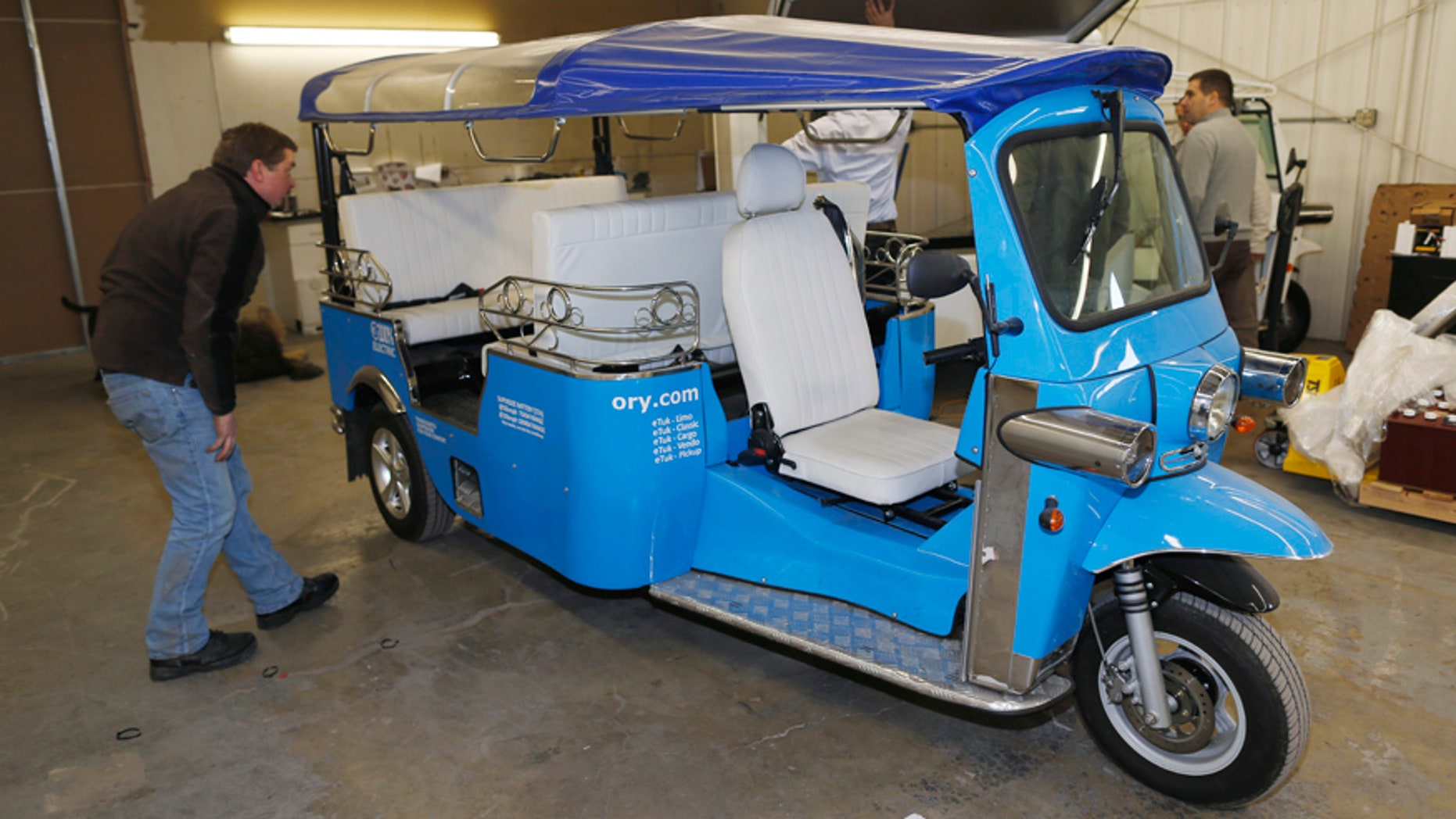 In this photo taken Friday, Feb. 27, 2015, a worker checks the roof on an electric Tuk-Tuk being prepared for export at the Denver eTuk factory in northeast Denver. The Tuk Tuk Factory, based in Amsterdam, has signed a licensing agreement with Denver-based eTuk USA to allow the company to manufacture and sell an electric version of the vehicle. The companys founders hope the eco-friendly vehicles, a far cry from the loud, pollution-spewing versions common in Asia and South America, will become the next hip mode of transportation for urban dwellers and tourists across the country. (AP Photo/David Zalubowski)