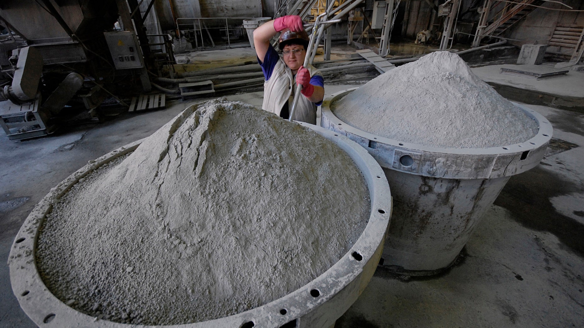 An employee controls the quality of tungsten concentrate at an ore-dressing mill at a Taiga settlement Vostok.