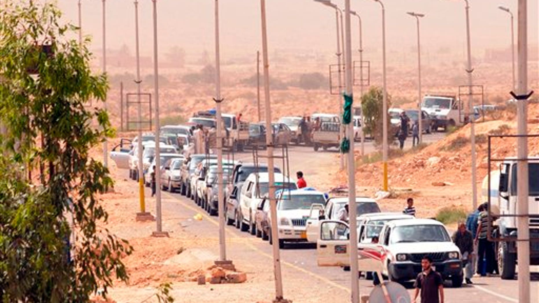Libyans flee from fighting as they cross the Dhiba border between Libya and Tunisia, Sunday, May 1, 2011. A battle between Libyan troops and rebels spilled over the border into Tunisia Friday, drawing a sharp rebuke of Muammar al-Qaddafi's regime from the neighboring government. The Tunisian army stopped members of Qaddafi's brigades, regrouping them and leading them back to Libyan territory, the Tunisian Defense Ministry said, and the Tunisian news agency, TAP, citing military officials, said dozens of Libyan troops and rebel fighters were killed in the two-day battle over the Dhuheiba crossing which ended with rebels regaining control Friday, after Libyan forces held it for a day. (AP)