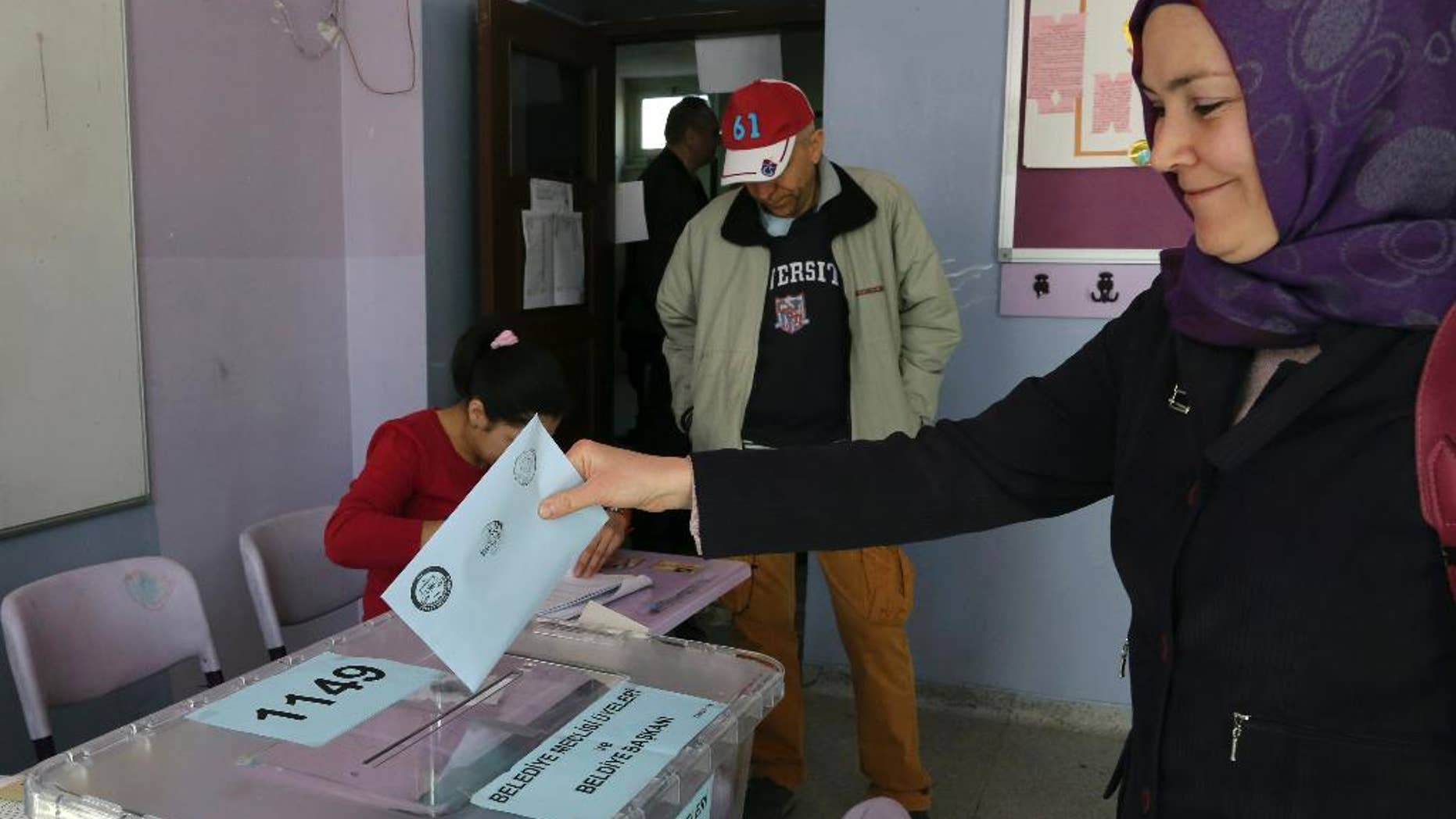 A Turkish woman casts her ballot at a polling station in Ankara Turkey, Sunday, March 30, 2014. More than 52 millions Turks vote in local elections Sunday as Turkish Prime Minister Recep Tayyip Erdogan is fighting corruption allegations against his government. The local elections are seen as a referendum over his rule.(AP Photo/Burhan Ozbilici)