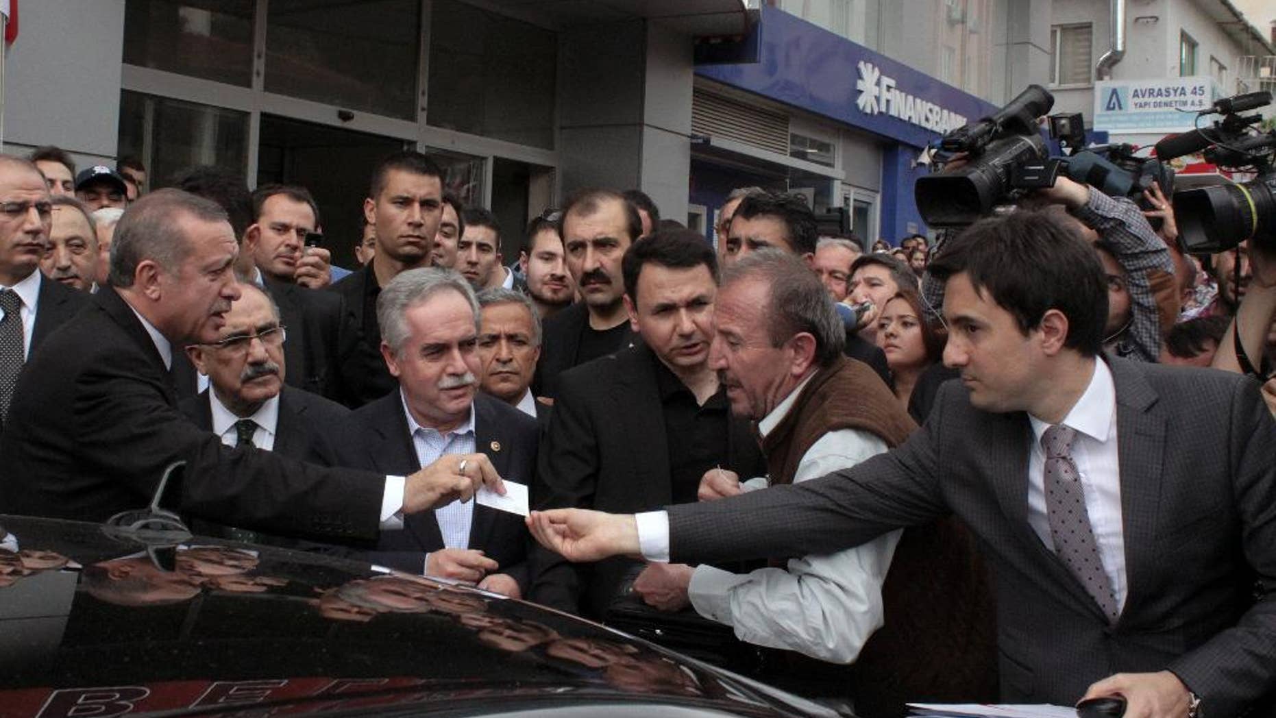 In this Wednesday, May 14, 2014 photo, Yusuf Yerkel, right, advisor to Turkish Prime Minister Recep Tayyip Erdogan, receives a note from Erdogan during his visit in Soma, Turkey. Yerkel identified by the Turkish media as the advisor who allegedly kicked a protester who was held by special forces police members during Erdogan's visit to Soma. Erdogan was visiting the western Turkish mining town of Soma after Turkey's worst mining accident.(AP Photo/Depo Photos) TURKEY OUT ONLINE OUT