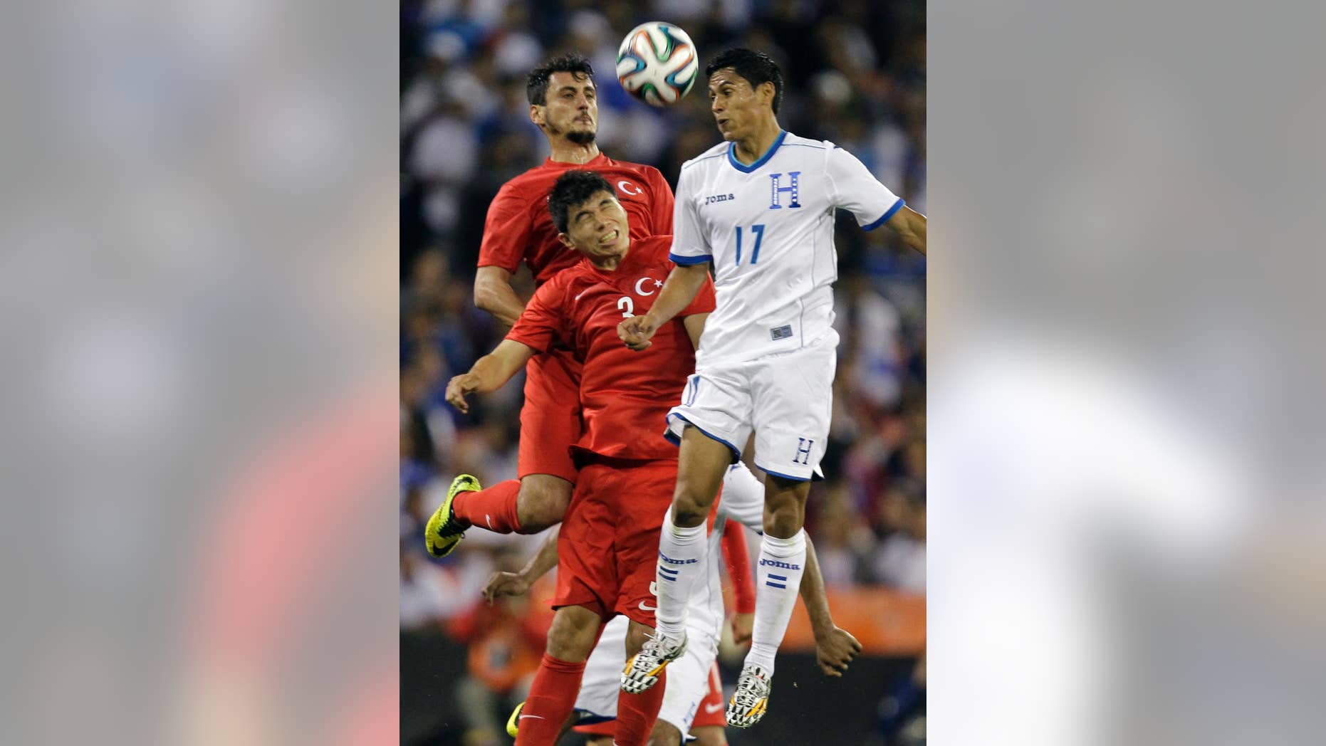 Turkey's Mustafa Pektemek, background, and Ishak Dogan (3) go up for the ball as Honduras’ Andy Najar (17) defends during the first half of an exhibition soccer game, Thursday, May 29, 2014, in Washington. (AP Photo/Luis M. Alvarez)