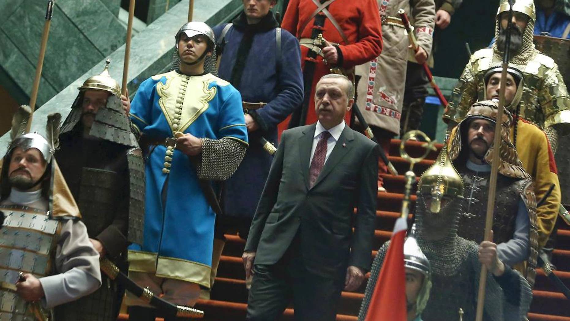 Turkish President Recep Tayyip Erdogan walks between the honor guards wearing historic Turkish warriors costumes before a ceremony for his Palestinian counterpart Mahmoud Abbas at his new presidential palace in Ankara, Turkey, Monday, Jan. 12, 2015. Abbas is in Turkey for a state visit.(AP Photo/Adem Altan, Pool)