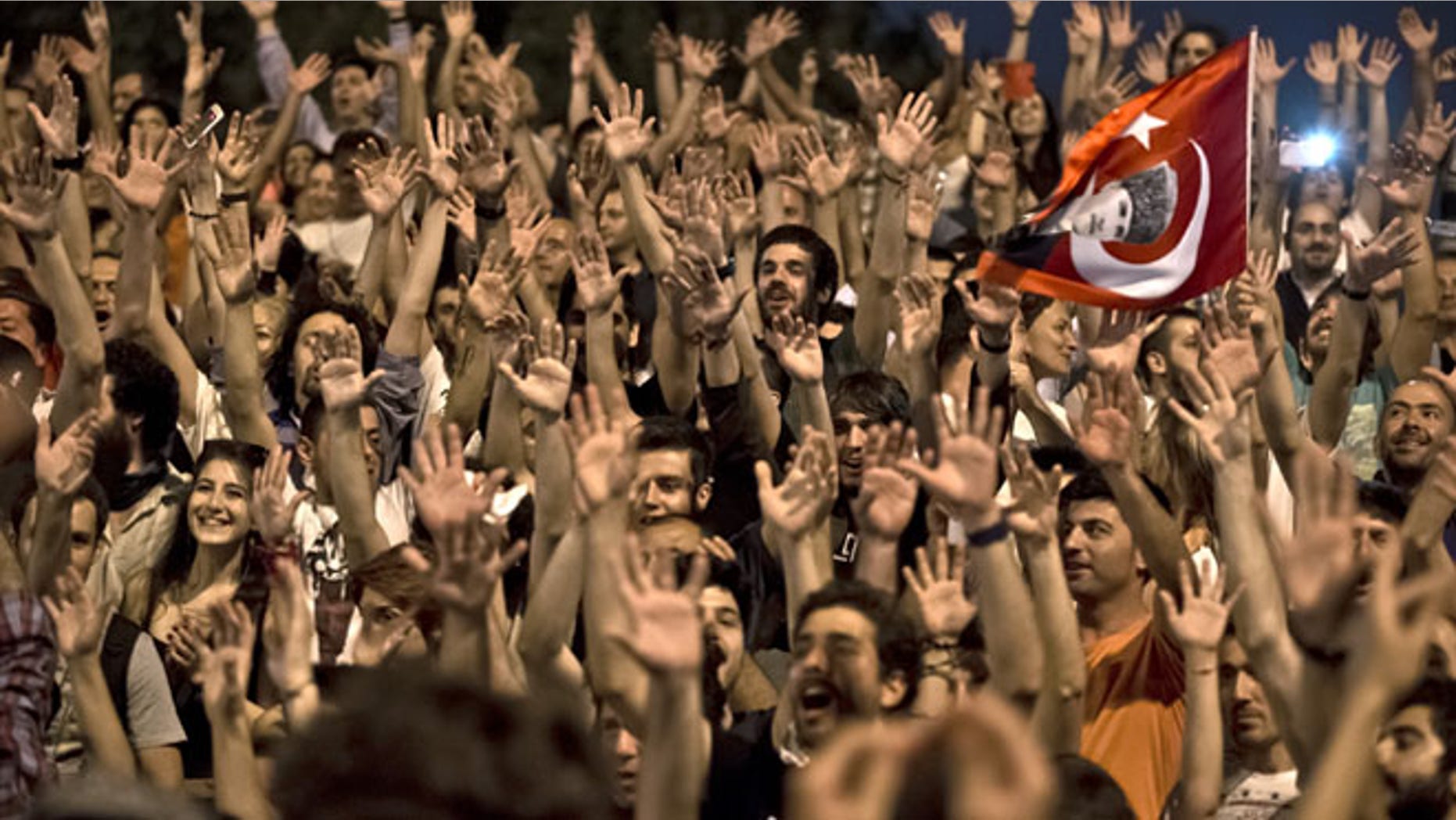 July 9, 2013: People celebrate on the steps leading to Gezi Park in Taksim square after Turkish riot police pulled back allowing them to enter the square in Istanbul, Turkey. Gezi Park remained open for the night after thousands of anti-government protesters broke their fast for the holy month of Ramadan by sitting down for a meal along a main Istanbul pedestrian street for a makeshift Ramadan banquet that stretched toward the city's landmark Taksim Square.