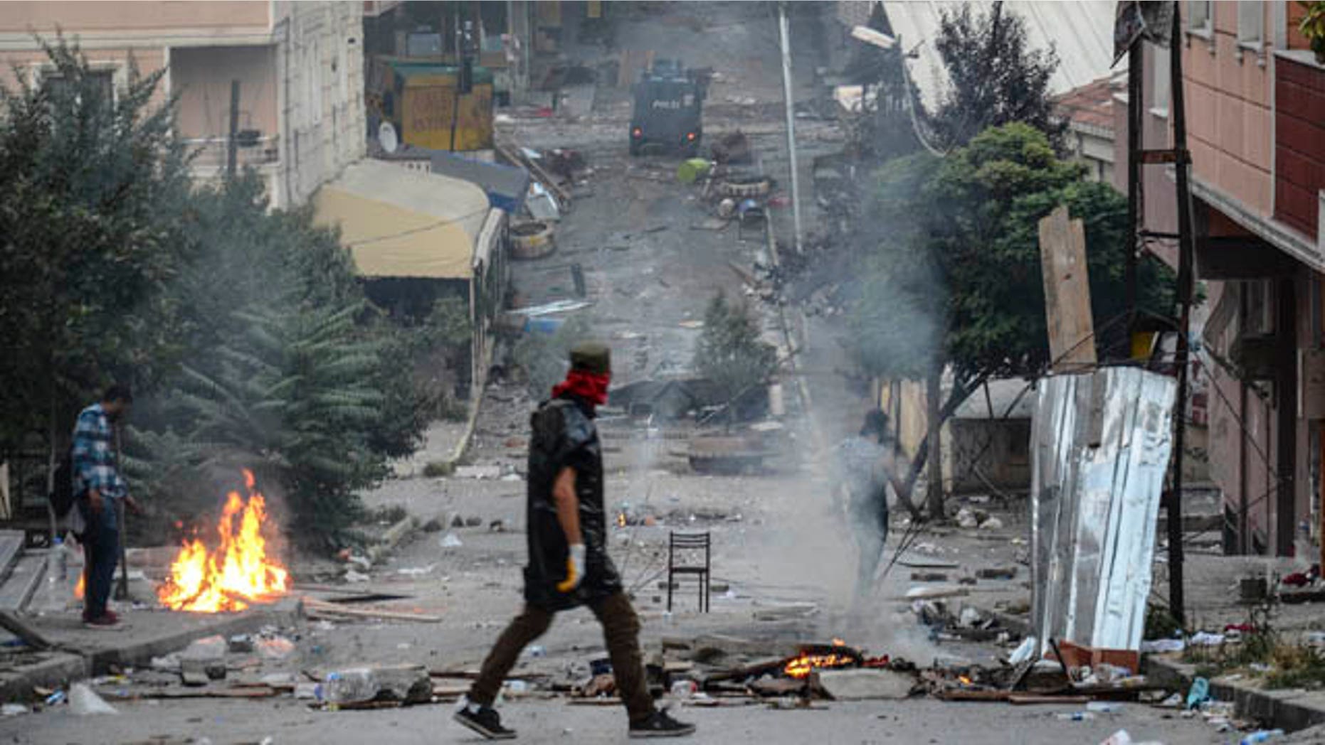 July 26, 2015: Makeshift barricades fill the streets as left-wing protesters light a fire trying to avoid tear gas used by police to disperse them during clashes between police and people protesting against Turkey's operation against Kurdish militants. (AP Photo/Cagdas Erdogan)