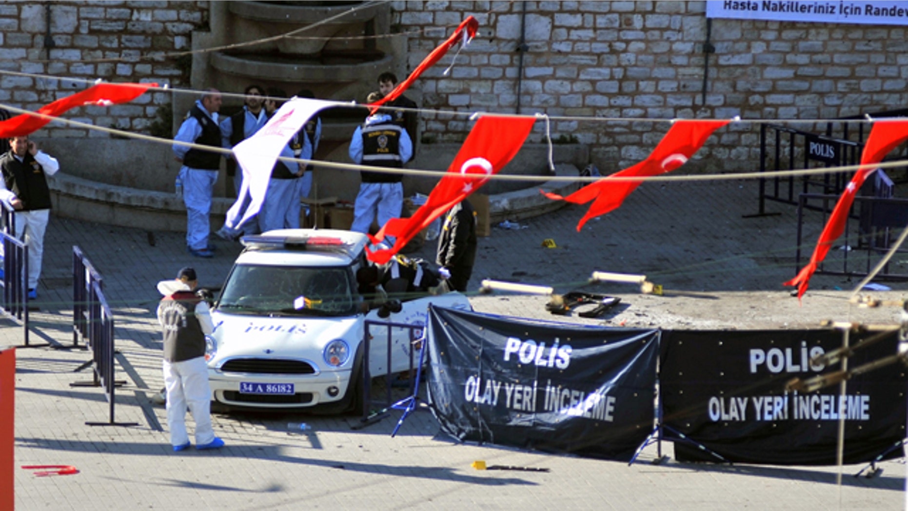 Police forensic officers inspect the scene after an explosion in Taksim square where riot police were stationed in case of demonstrations in Istanbul, Turkey, Sunday, Oct. 31, 2010. A suspected suicide bomber detonated a device in Istanbul's main square on Sunday, wounding 32 people, Istanbul's police chief said.