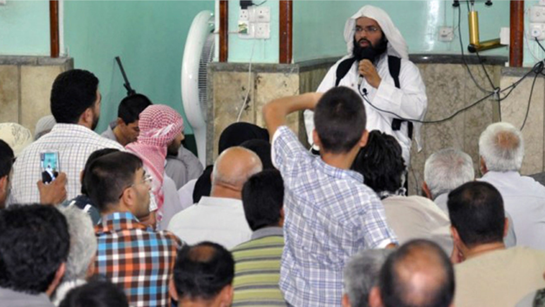 In this undated image obtained from a militant website on Dec. 12, 2014, Turki al-Binali, a Bahraini citizen who is also known among jihadis by two other names: Abu Sufian al-Silmi and Abu Hummam al-Athari, gives a lecture to dozens of worshippers and jihadi fighters inside a mosque in the northern Iraqi city of Mosul during the Muslim holy month of Ramadan in mid-2014. Al-Binali has risen in the ranks of the Islamic State group to become one of its top and most influential religious figures.