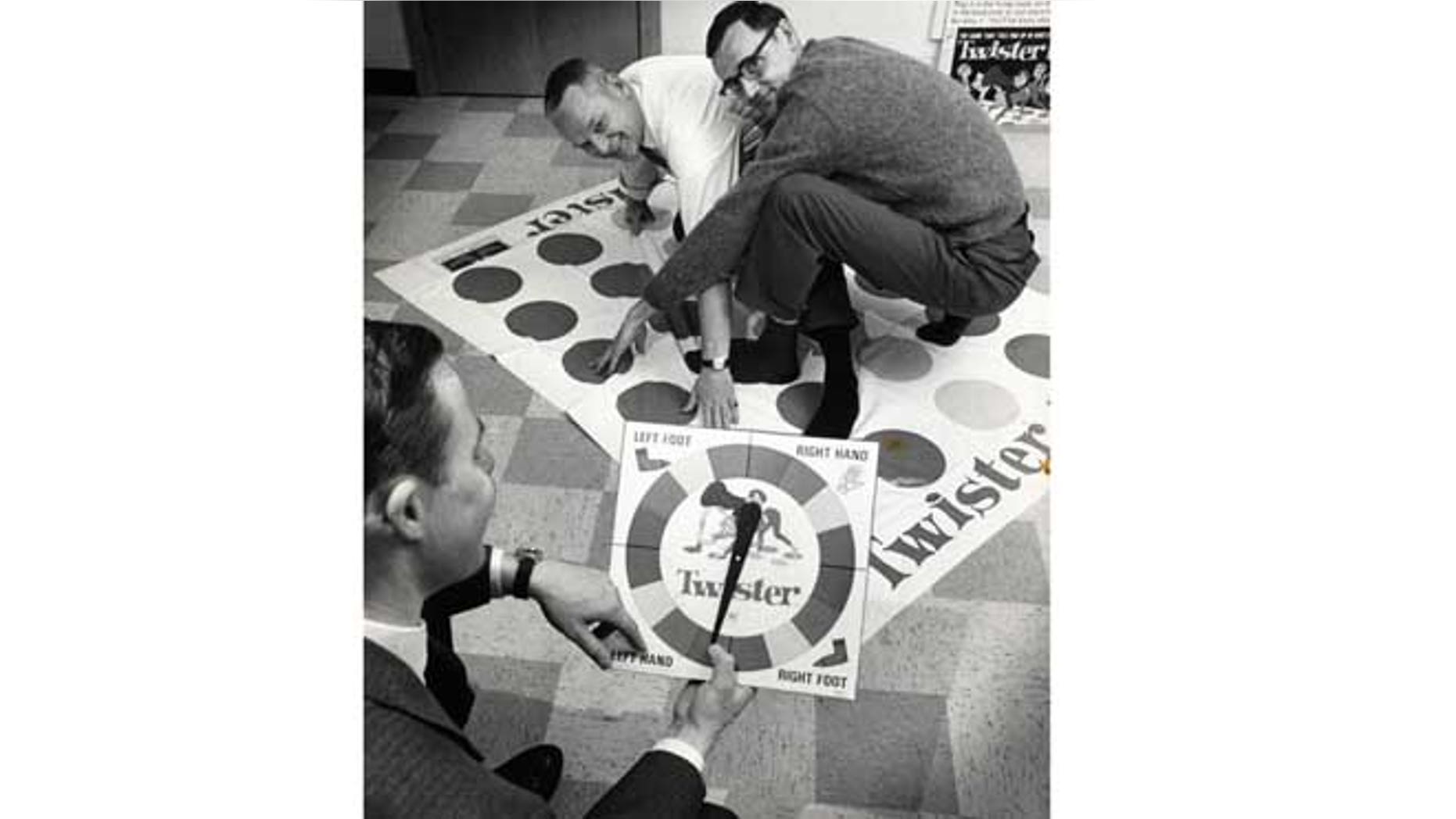 Dec. 16,1966: In this photo, co-inventors of the game "Twister" Charles Foley, left, and Neil Rabens demonstrate the game for Charles McCarty, foreground, president of Research and Development, Inc., in Minnesota.