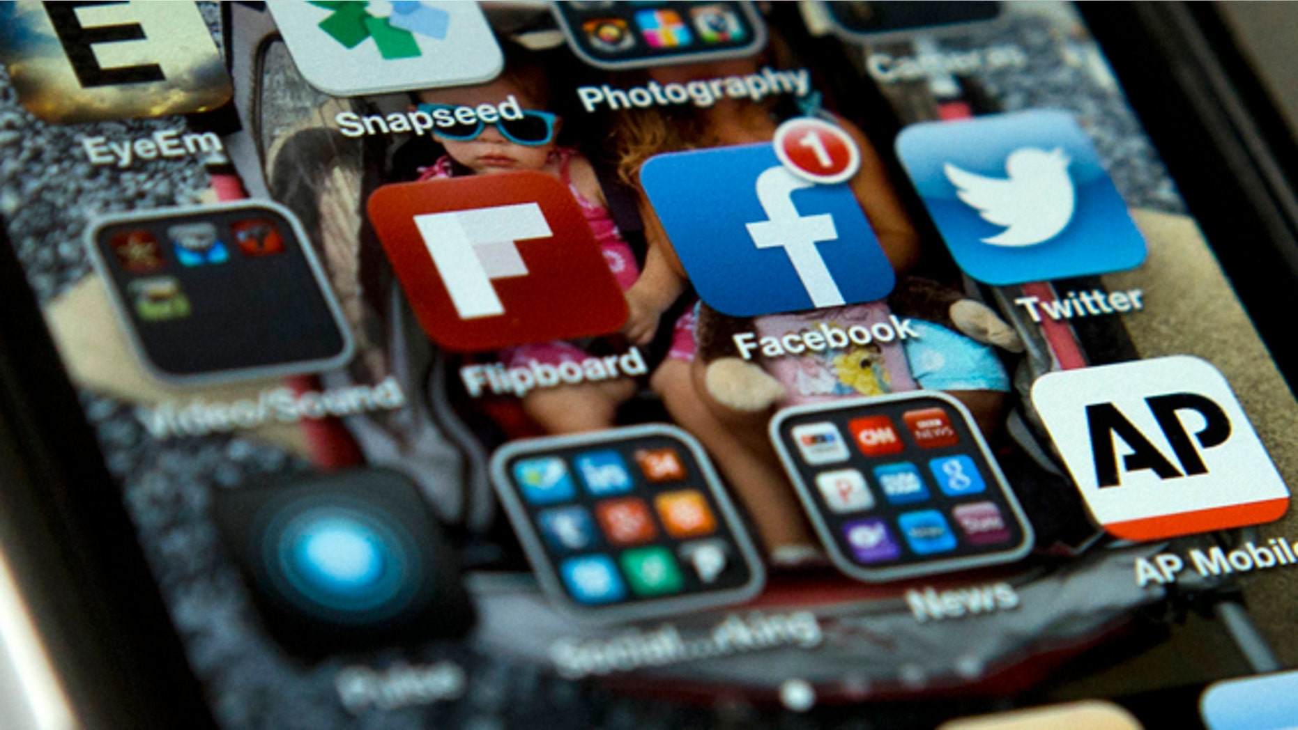 A view of an iPhone in Washington Tuesday, May 21, 2013, showing the Twitter and Facebook apps among others. A new poll finds that teens are sharing more about themselves on social media. Theyâre also moving increasingly to Twitter to avoid their parents and the "oversharing" that they see on Facebook. (AP Photo/Evan Vucci)