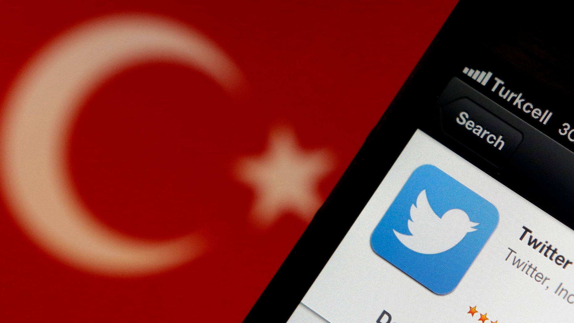 A Twitter logo on an iPhone display is pictured next to a Turkish flag in this photo illustration taken in Istanbul March 21, 2014.